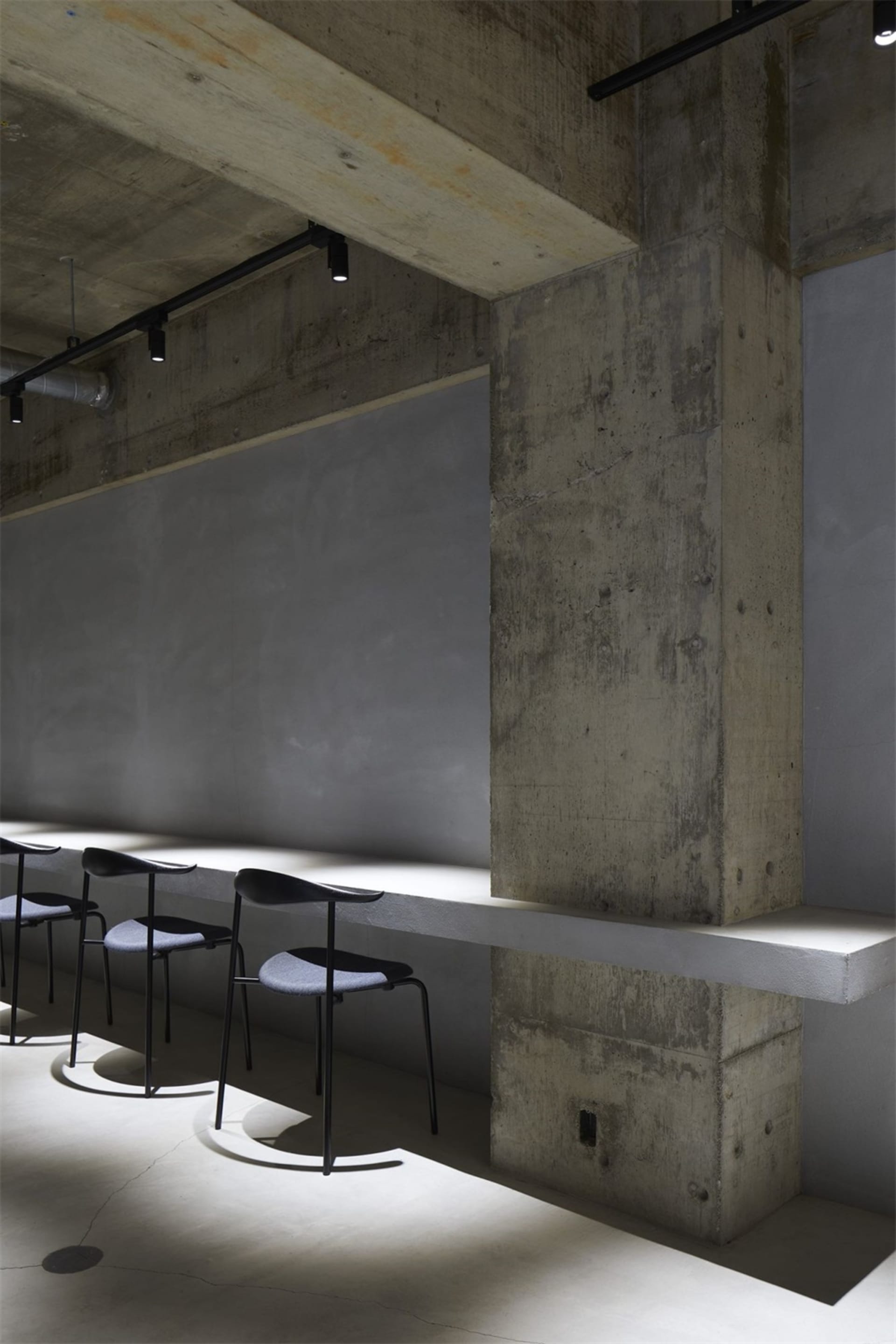 Modernist industrial commercial interior space with concrete walls and minimalist design.