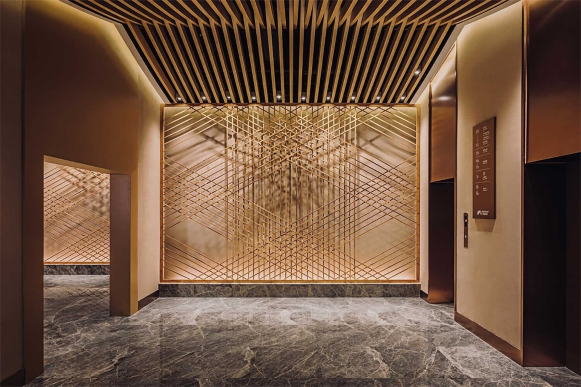 Modern hotel lobby featuring metal, glass, and marble materials.