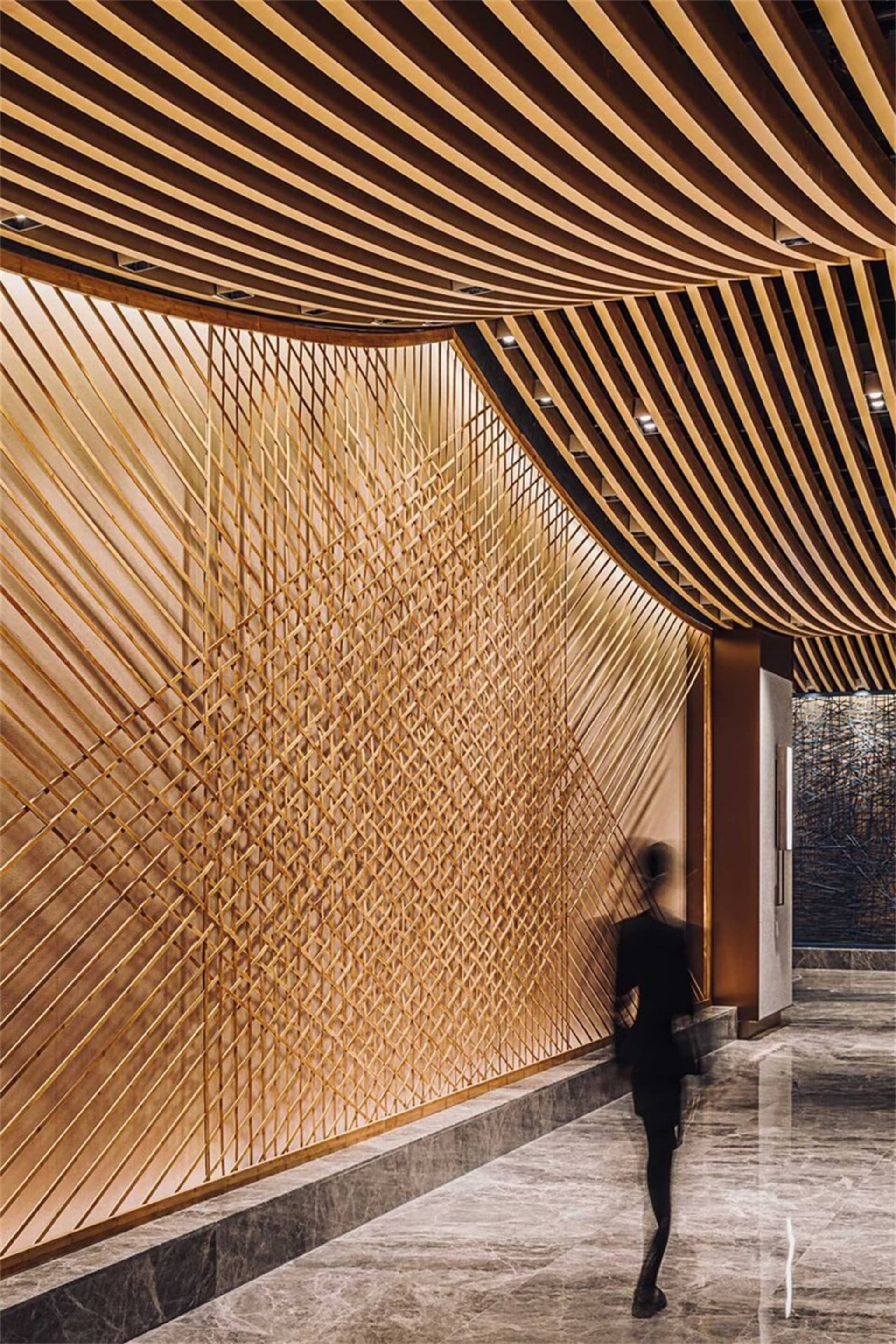 Modern lobby featuring a wooden wall design with linear patterns.