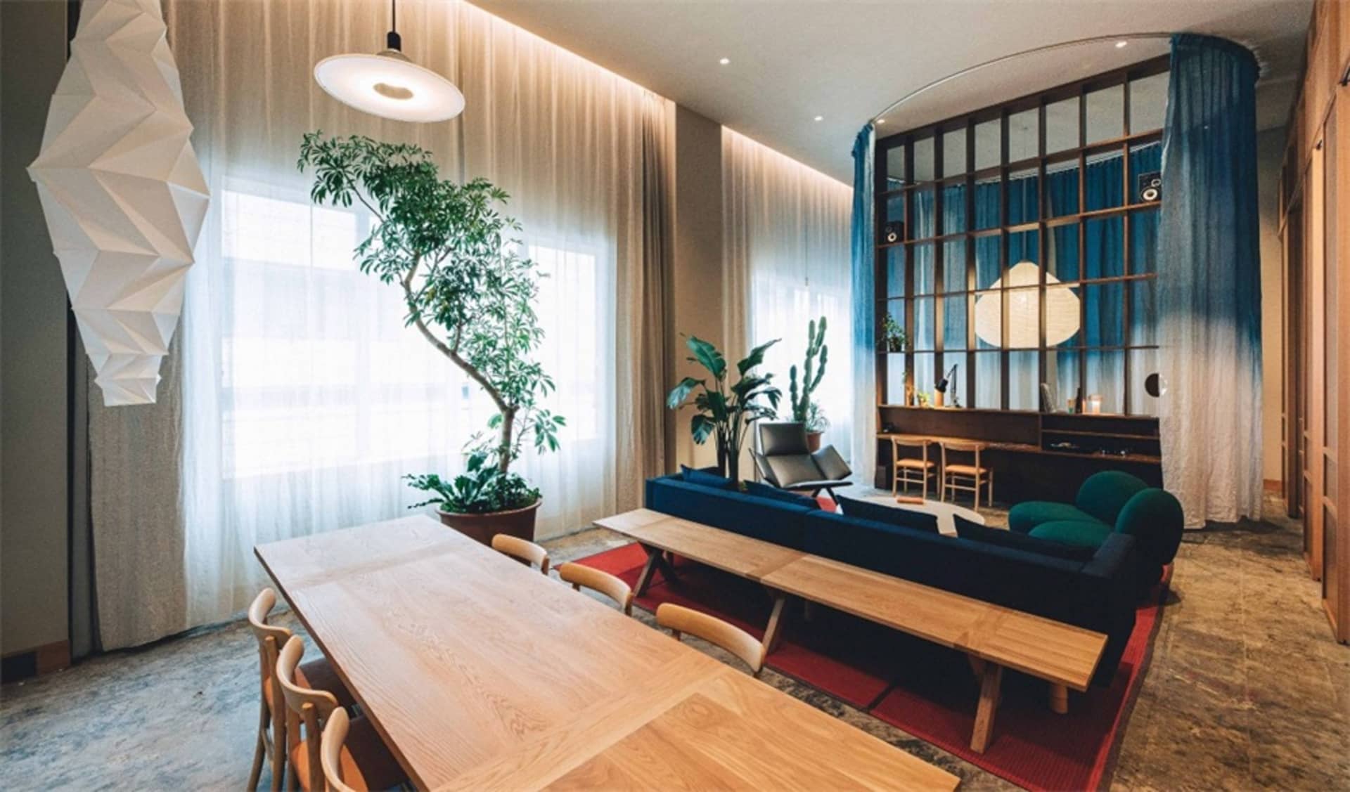 A minimalist living room featuring wooden furniture and glass partitions.