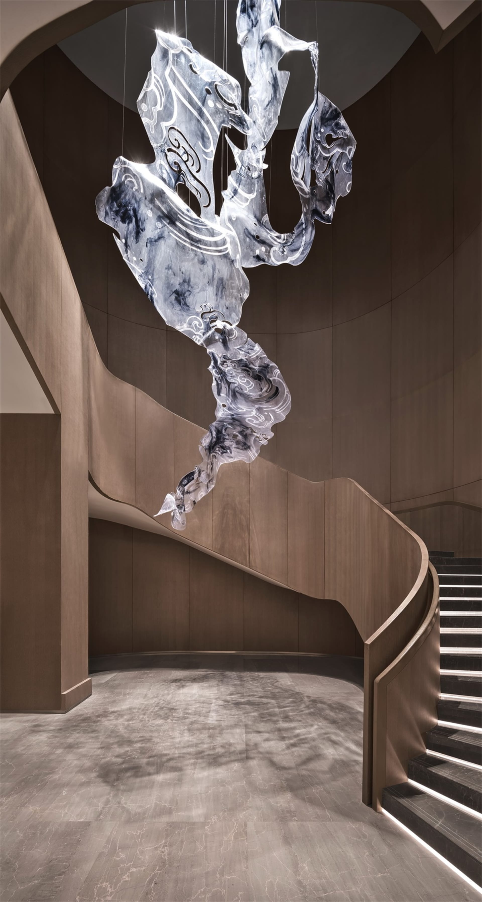 A modern marble lobby featuring intricate lighting fixtures.