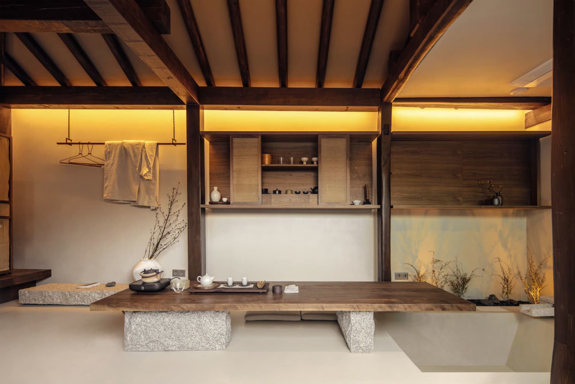 A modern tea room featuring wooden shelves and a stone floor.