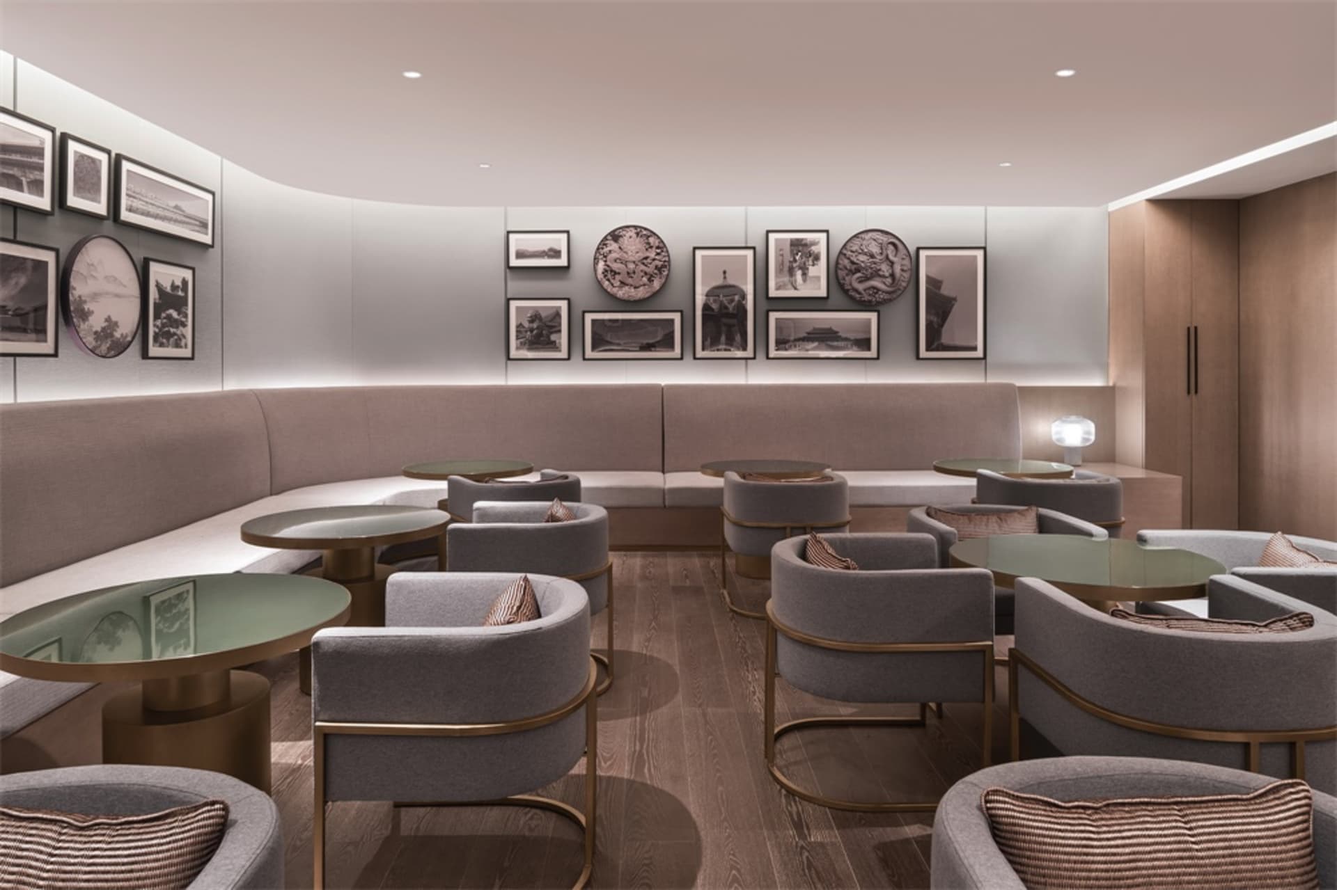 Modern coffee shop interior with fabric seating, wooden flooring, and framed art on the walls