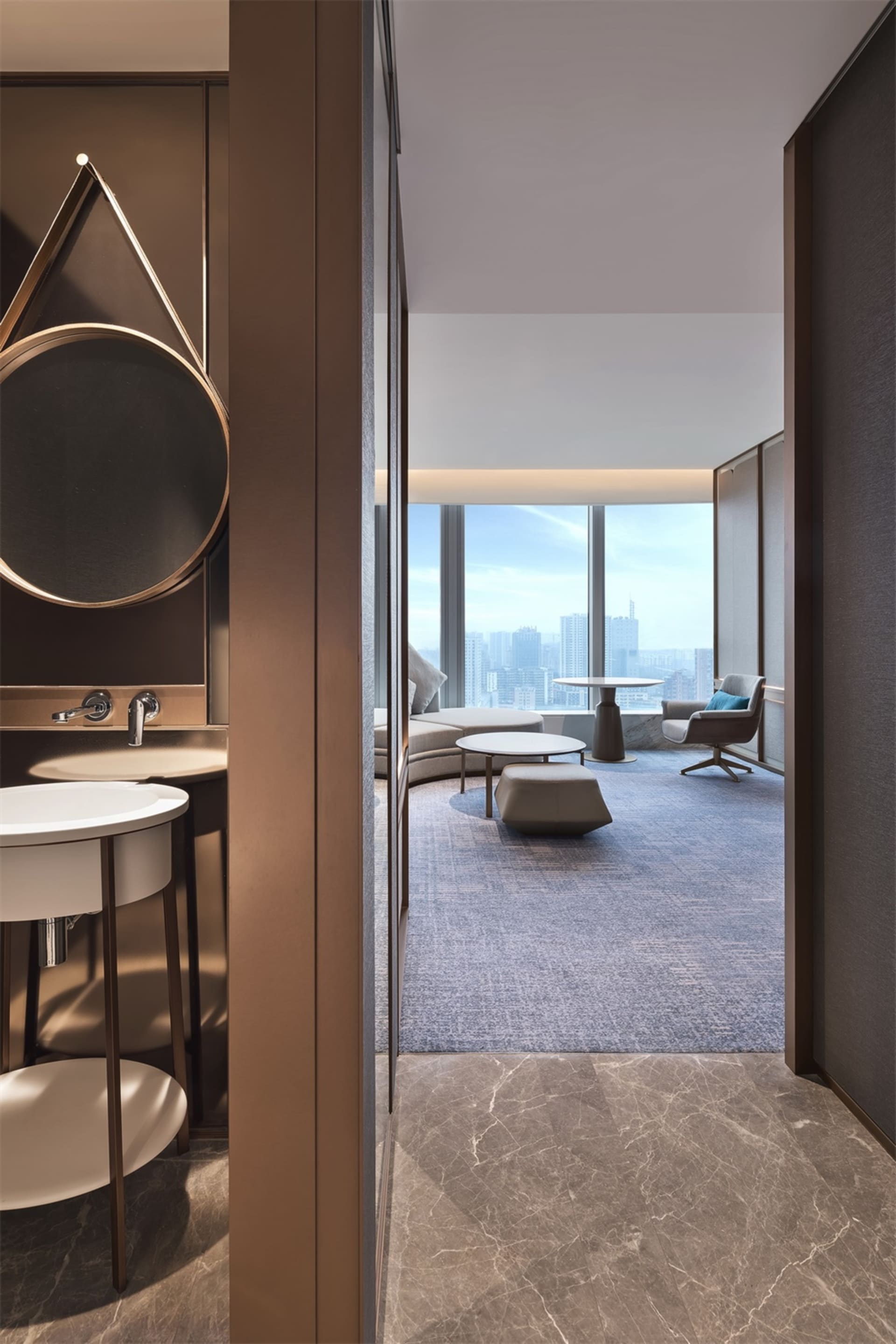 A modern living room featuring marble surfaces, glass elements, and leather furniture.