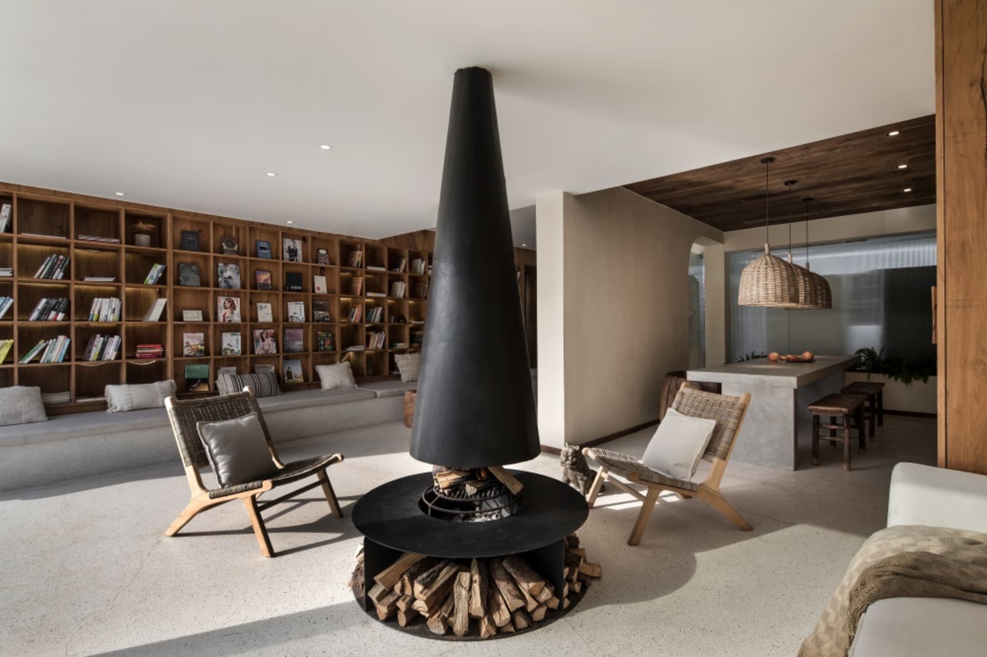 A modern living room featuring a concrete fireplace and built-in bookshelves.