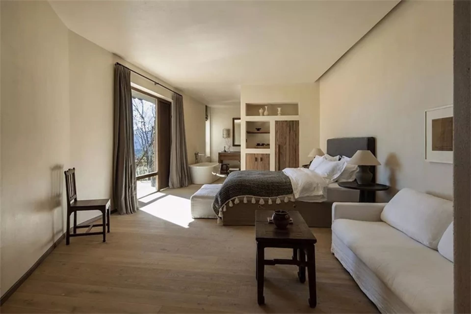 A minimalist bedroom featuring wood paneling and cloth textiles.