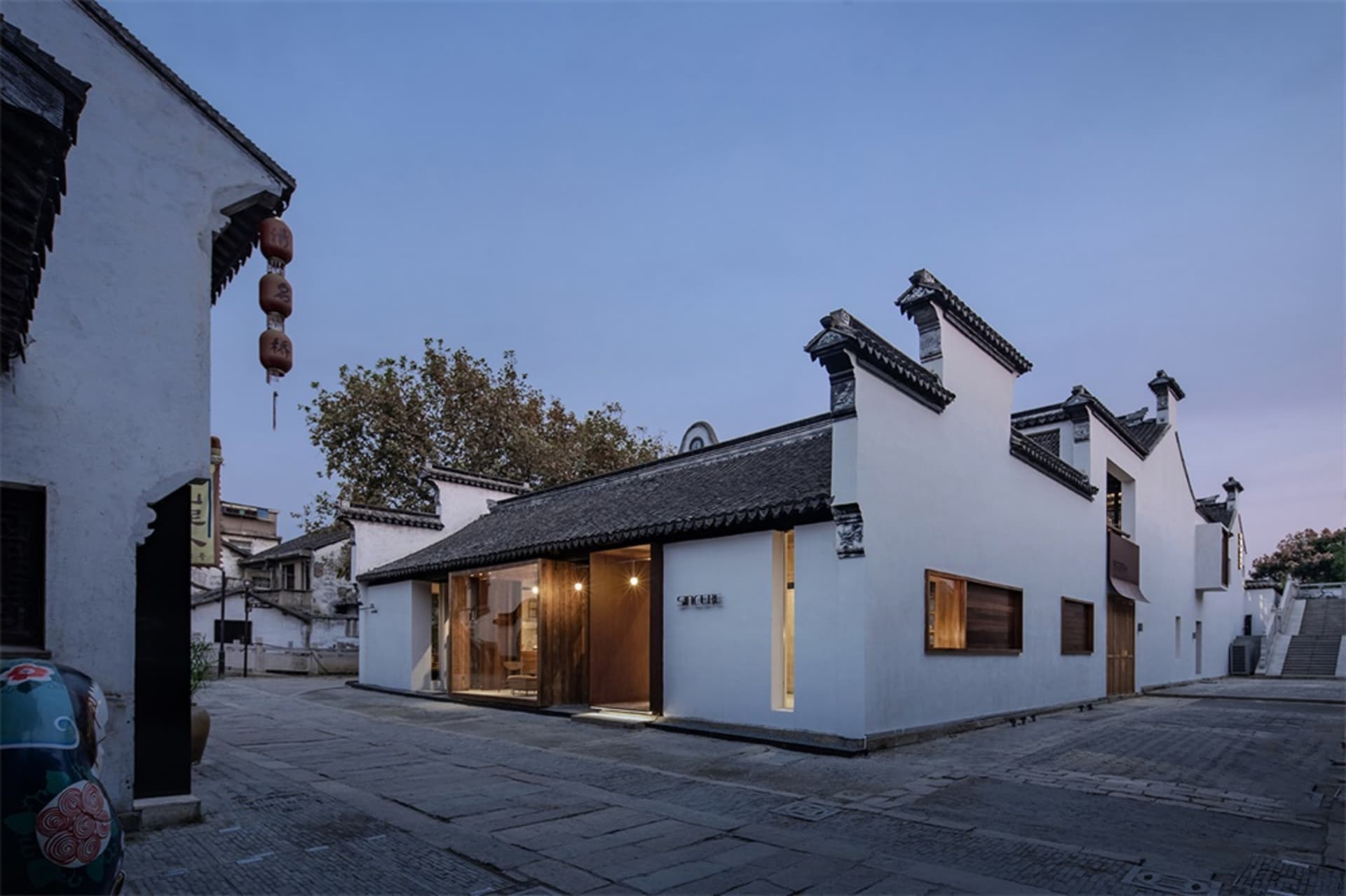 A traditional Chinese building with a white painted brick exterior at dusk.