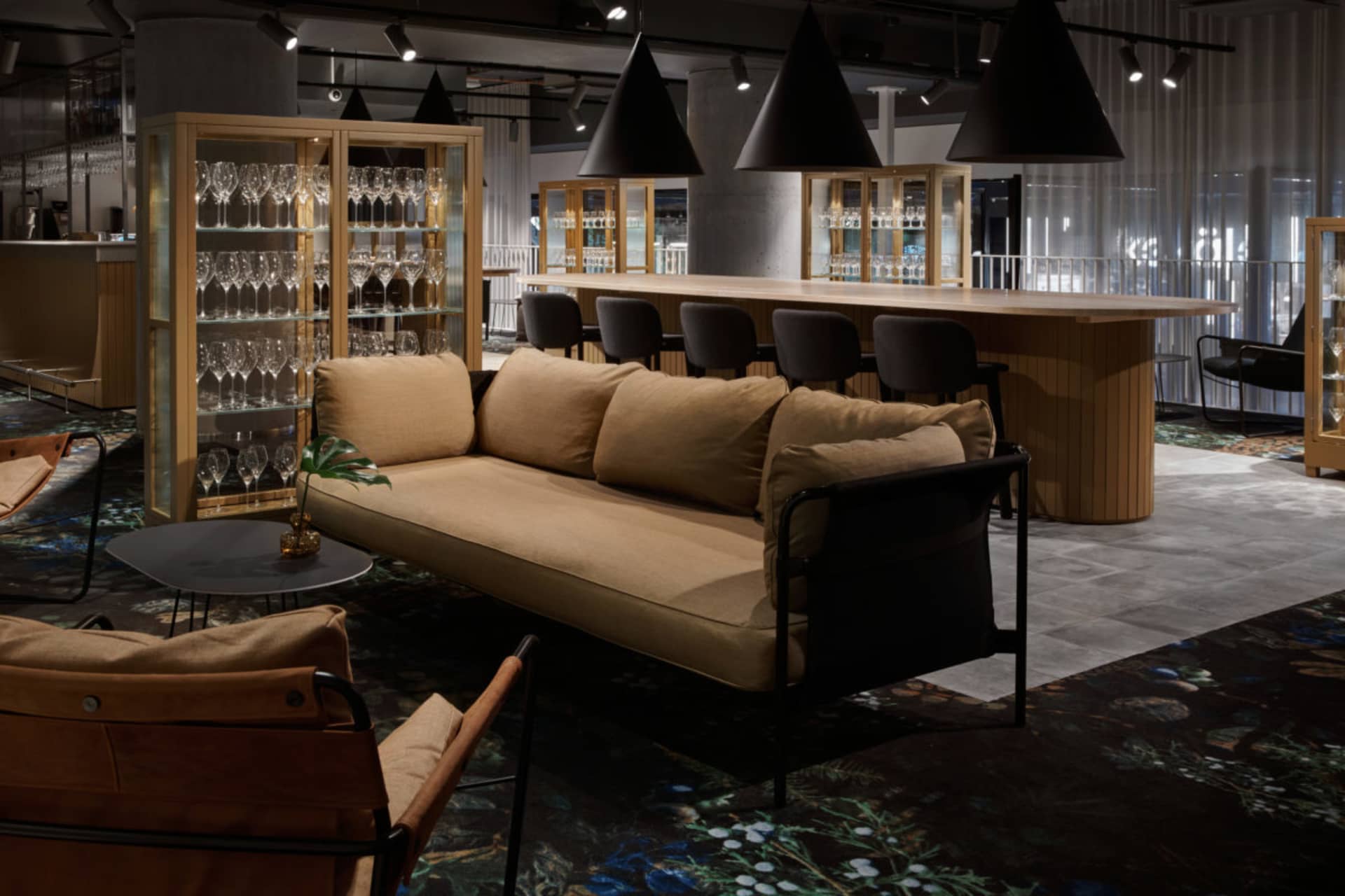 現代酒店大廳，陳設木質家具、玻璃櫃與皮革細節。