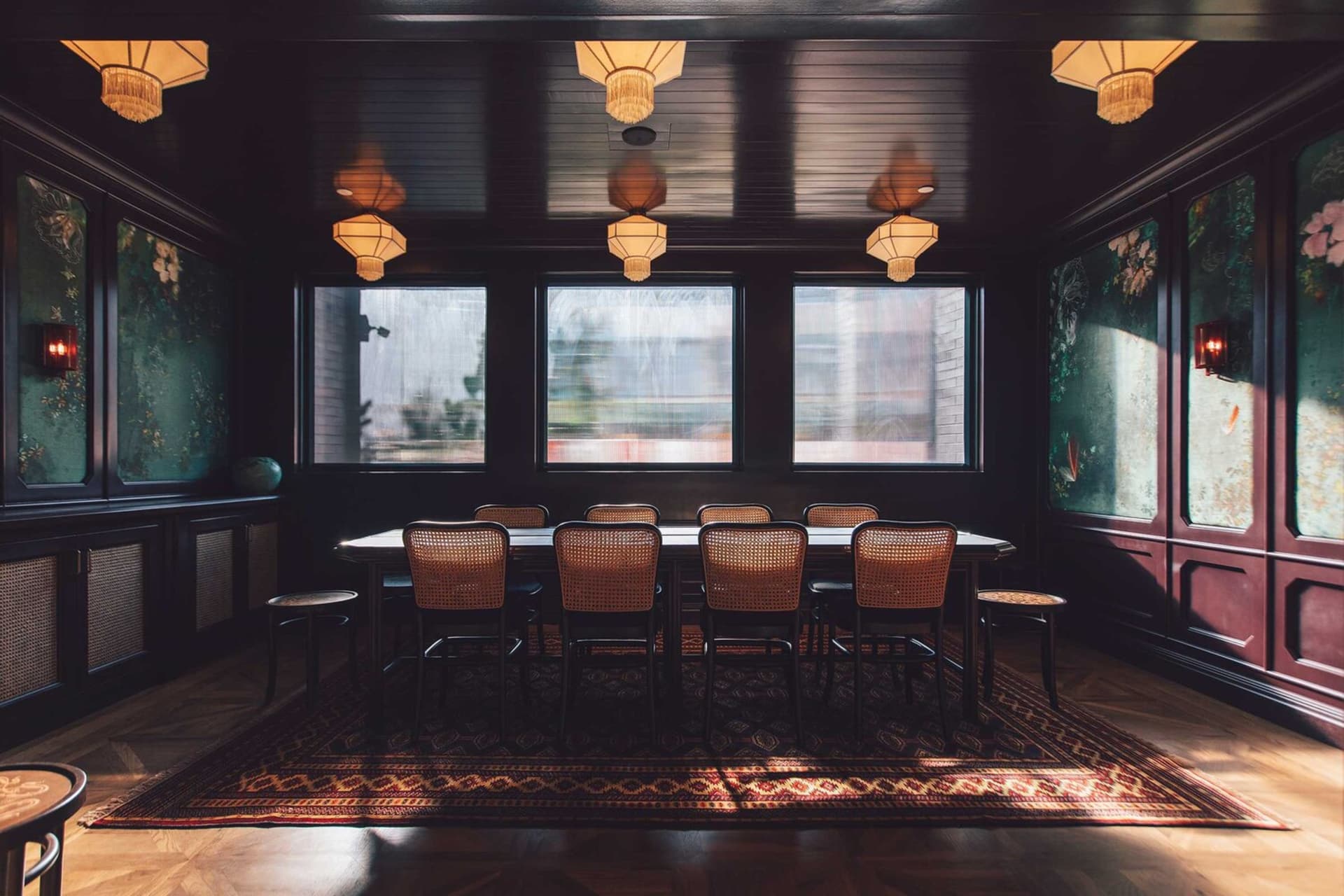 A sophisticated, modern restaurant interior with wooden tables, leather chairs, and glass window panels.