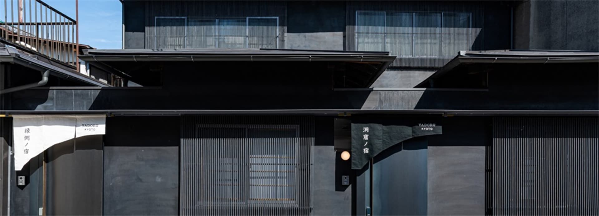 A modern building facade with metal panels and a blurred background.