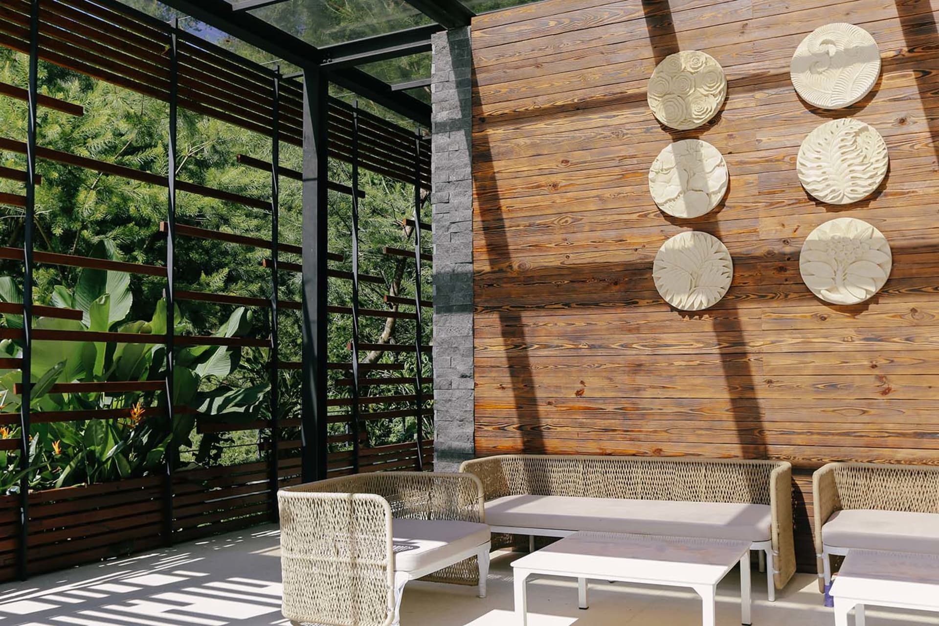A wooden-walled cozy indoor living space featuring a contemporary sofa and decorative wall plates.