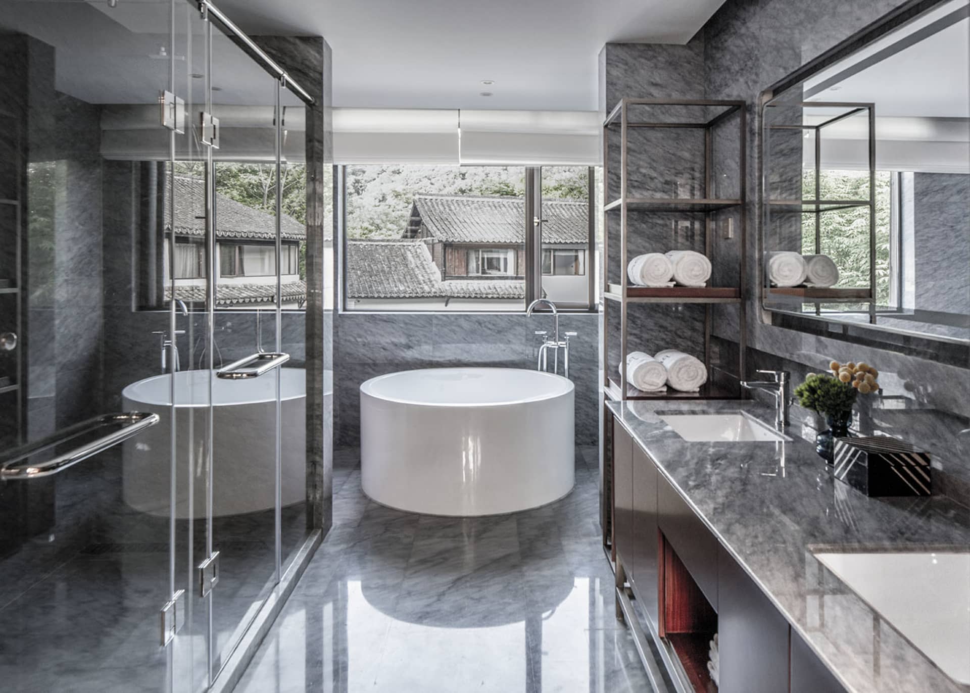 A modern bathroom interior featuring a marble and concrete design with a circular bathtub and minimalist fixtures.