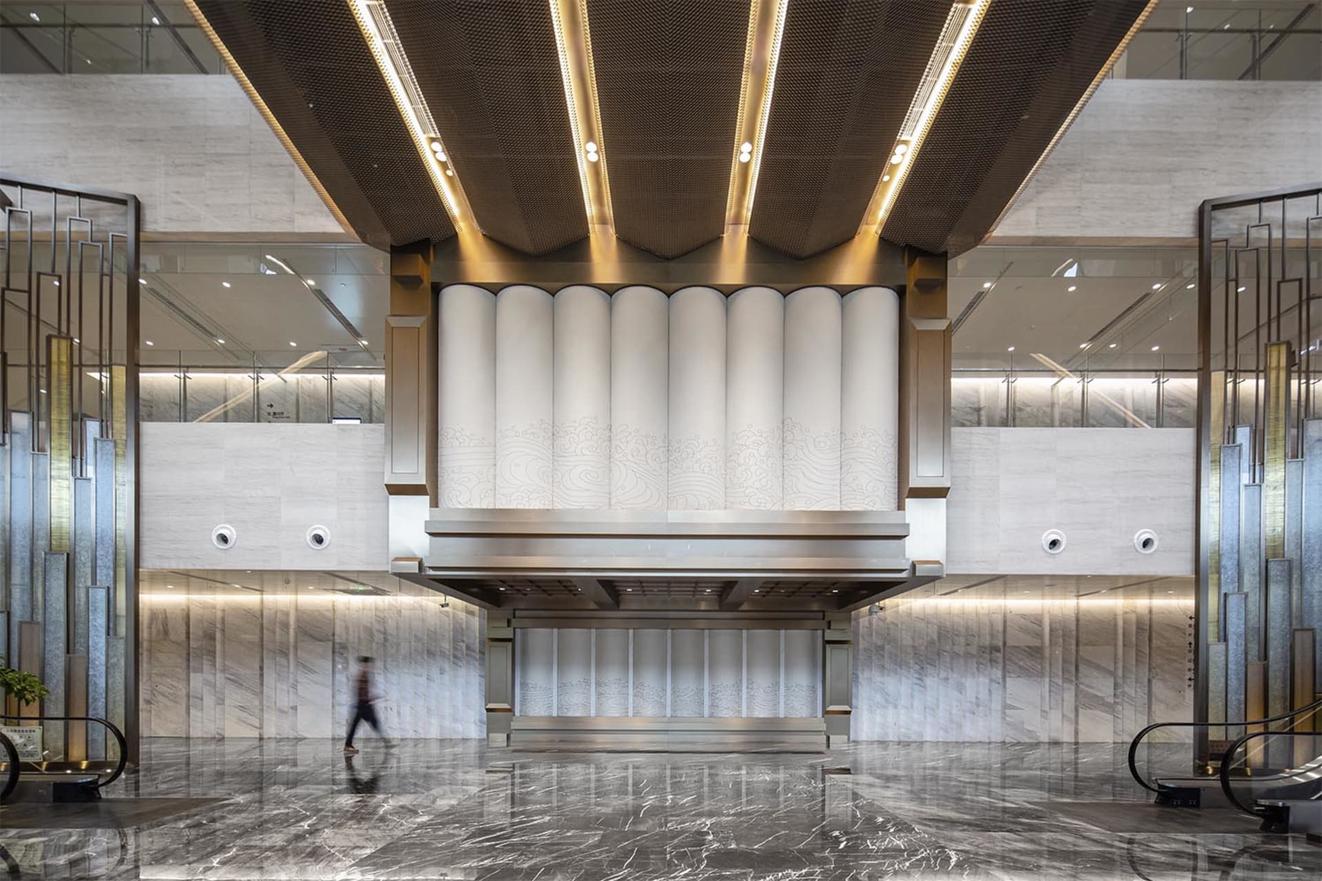 Modern office lobby featuring marble, concrete, and metallic finishes.