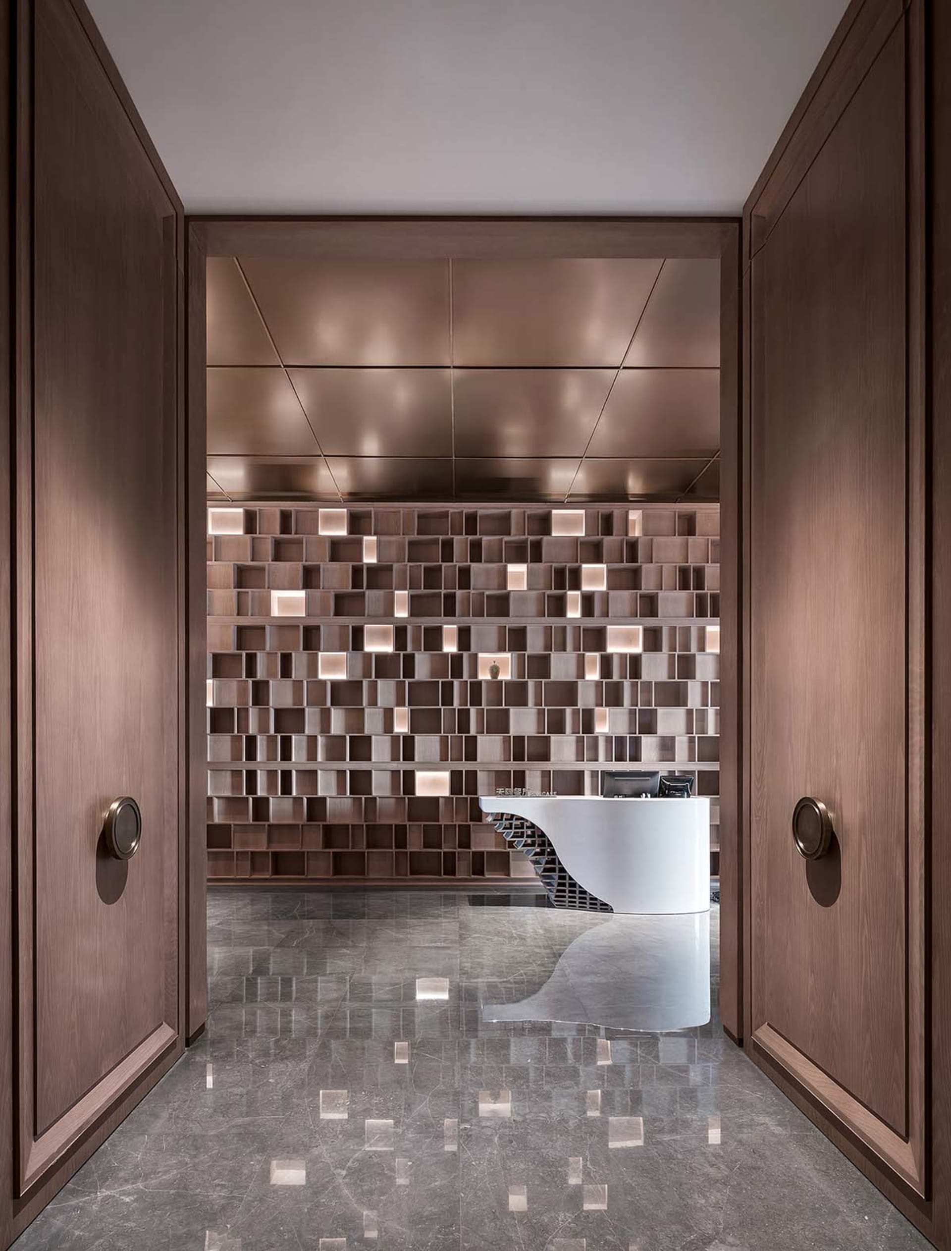 Modern reception area with wooden paneling and a white curved reception desk.