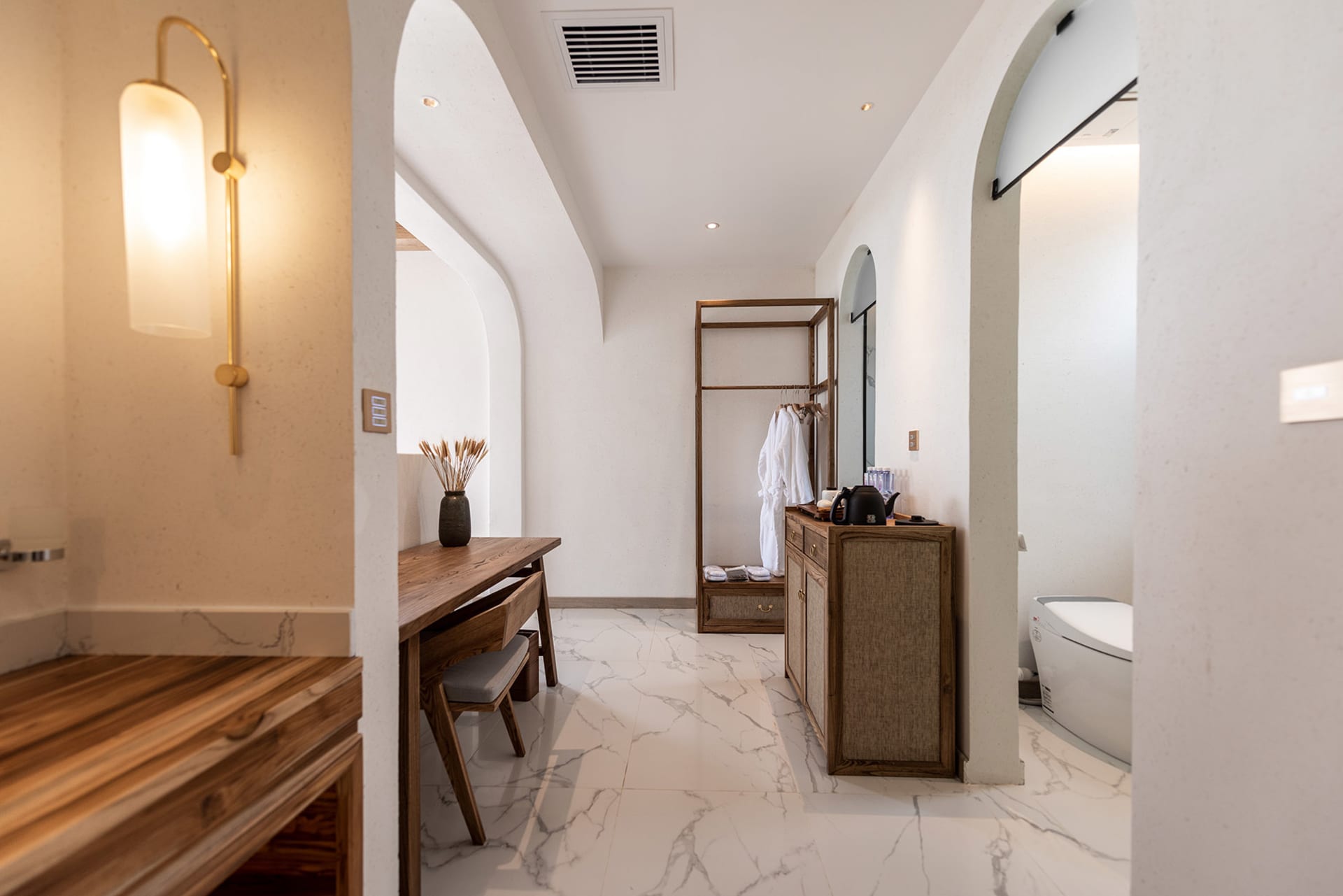 Modern bathroom with marble flooring, minimalist design, and industrial-style lighting fixtures.
