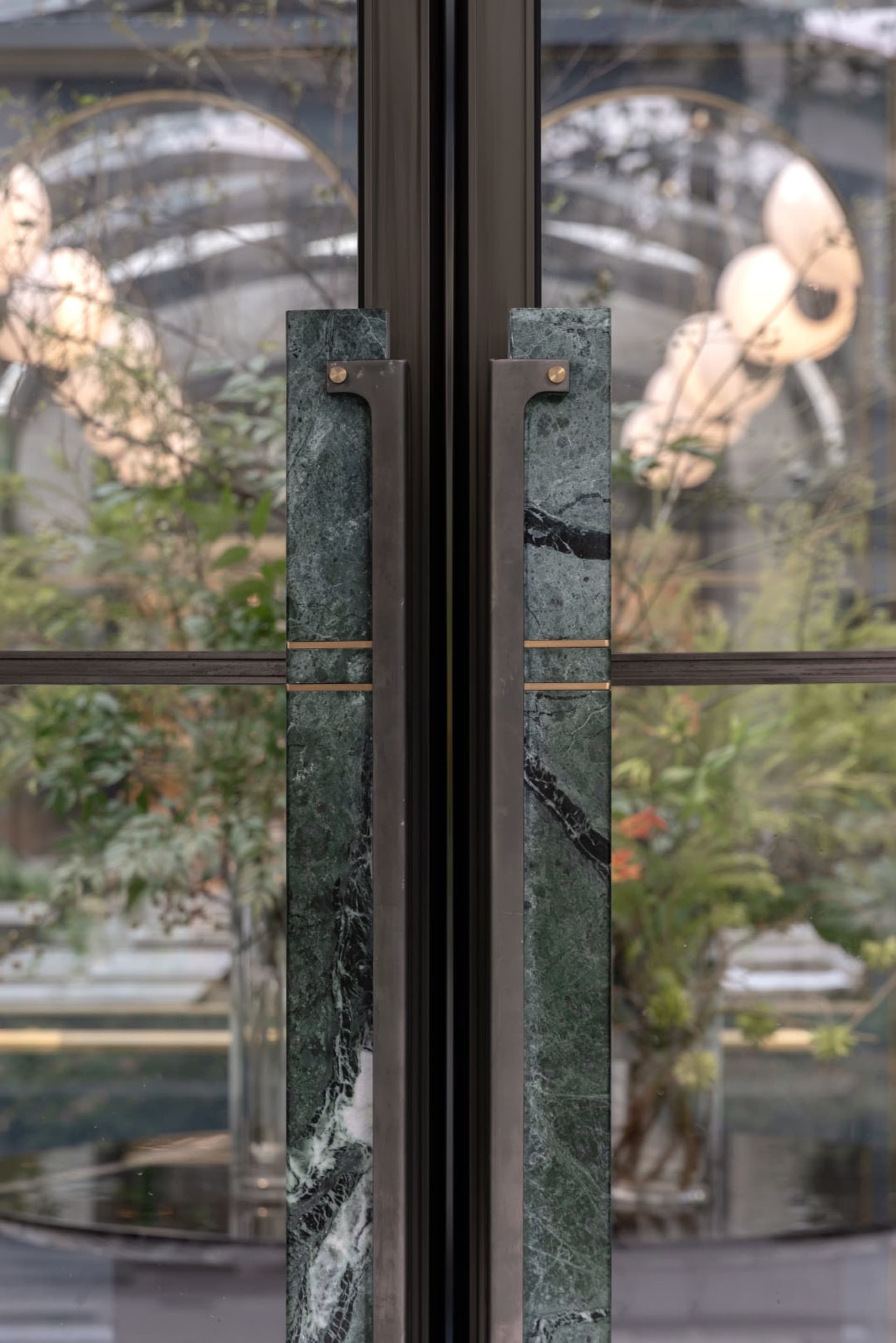 Green marble and steel double doors with modern handles.