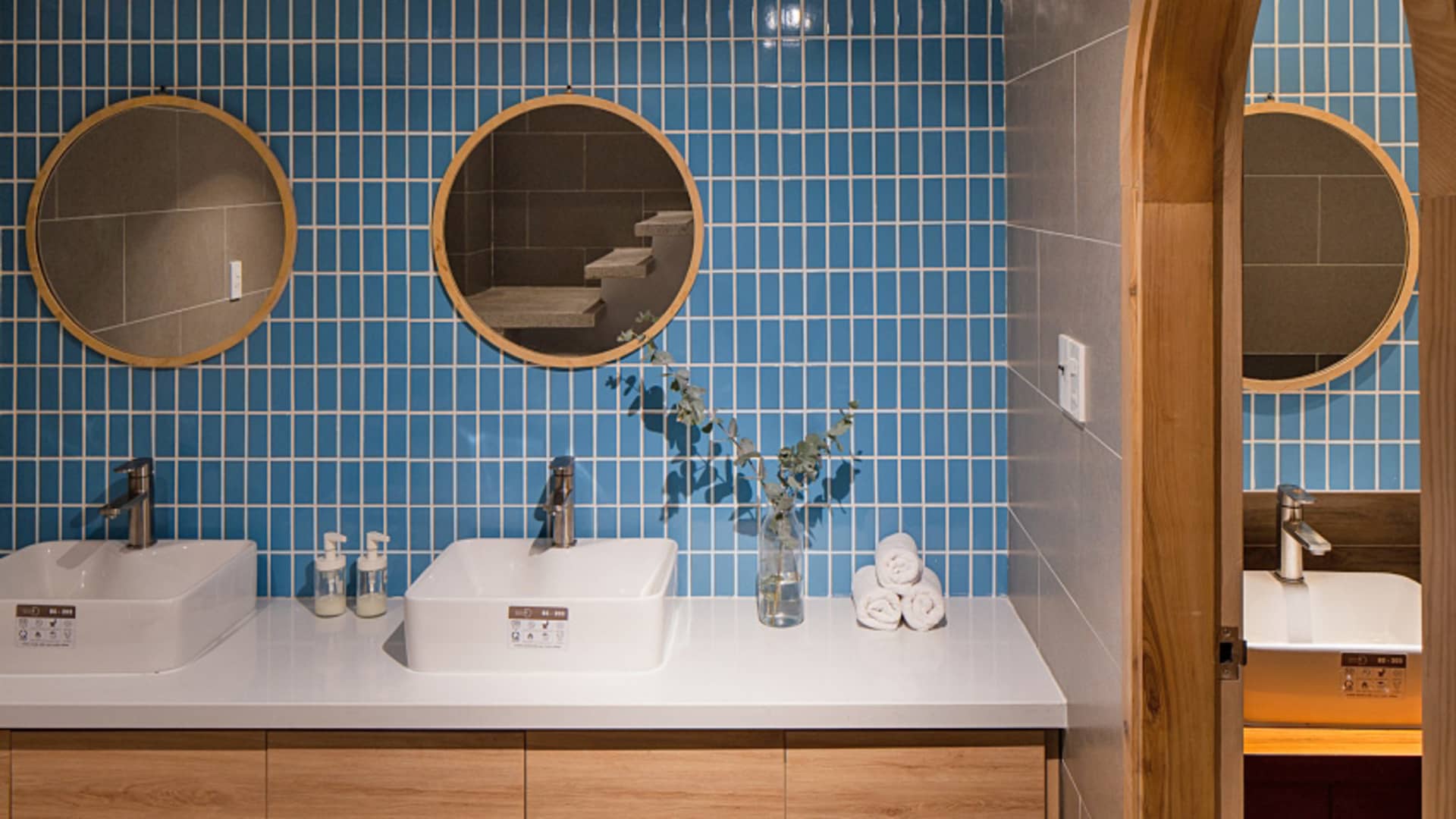Modern bathroom with blue tiles and wooden countertop