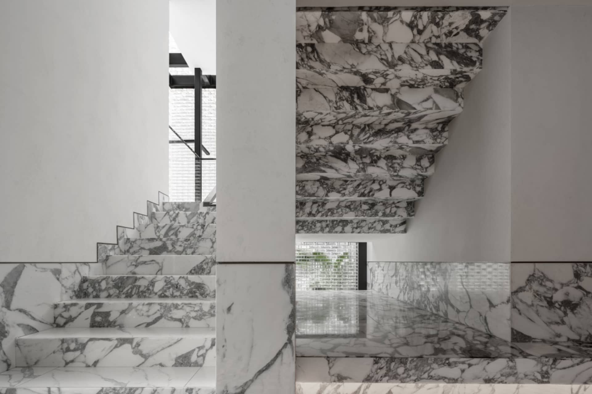 A staircase with marble steps and walls in a modern interior.