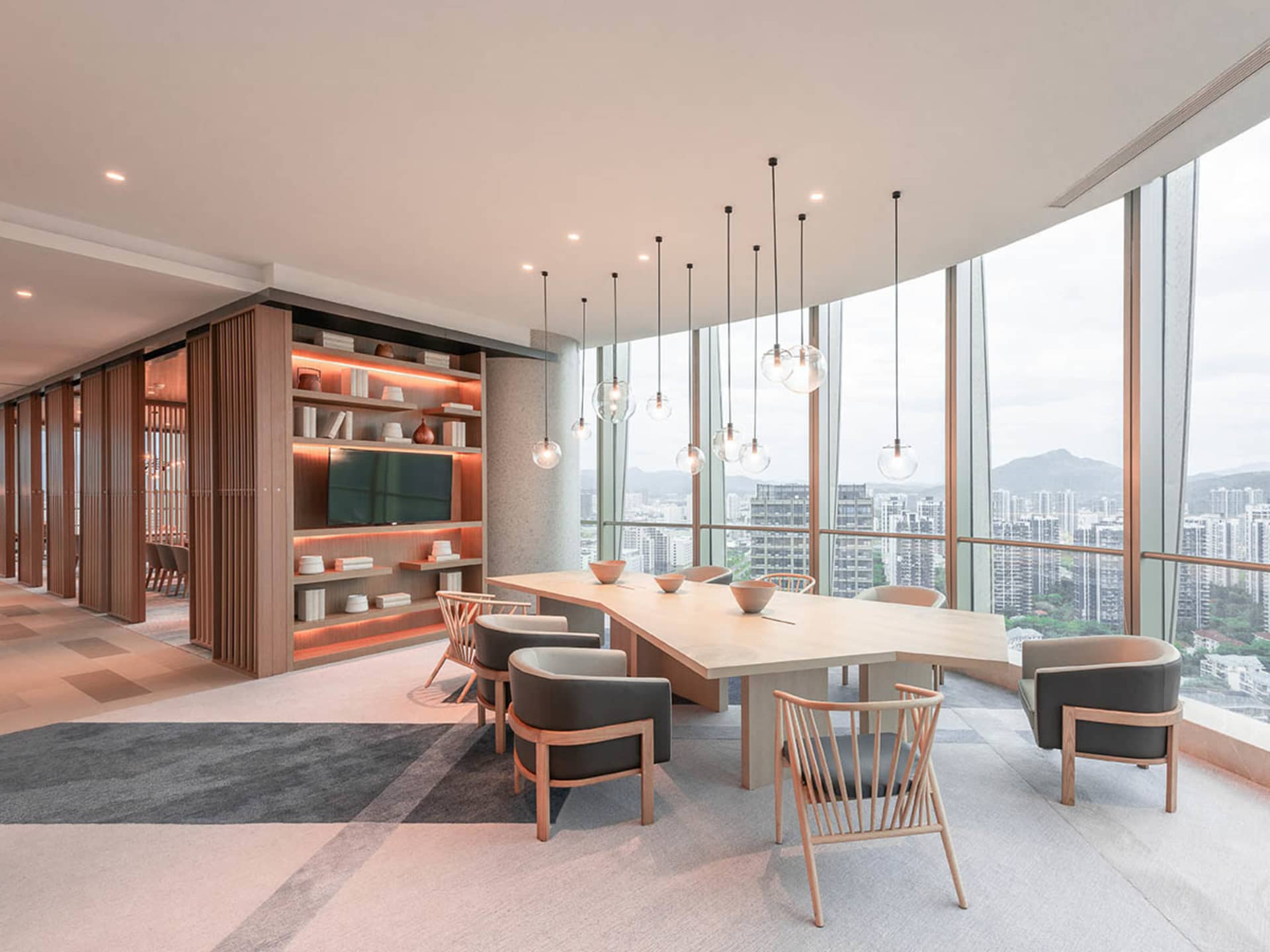 Modern office conference room with contemporary wood accents and floor-to-ceiling windows overlooking a cityscape.