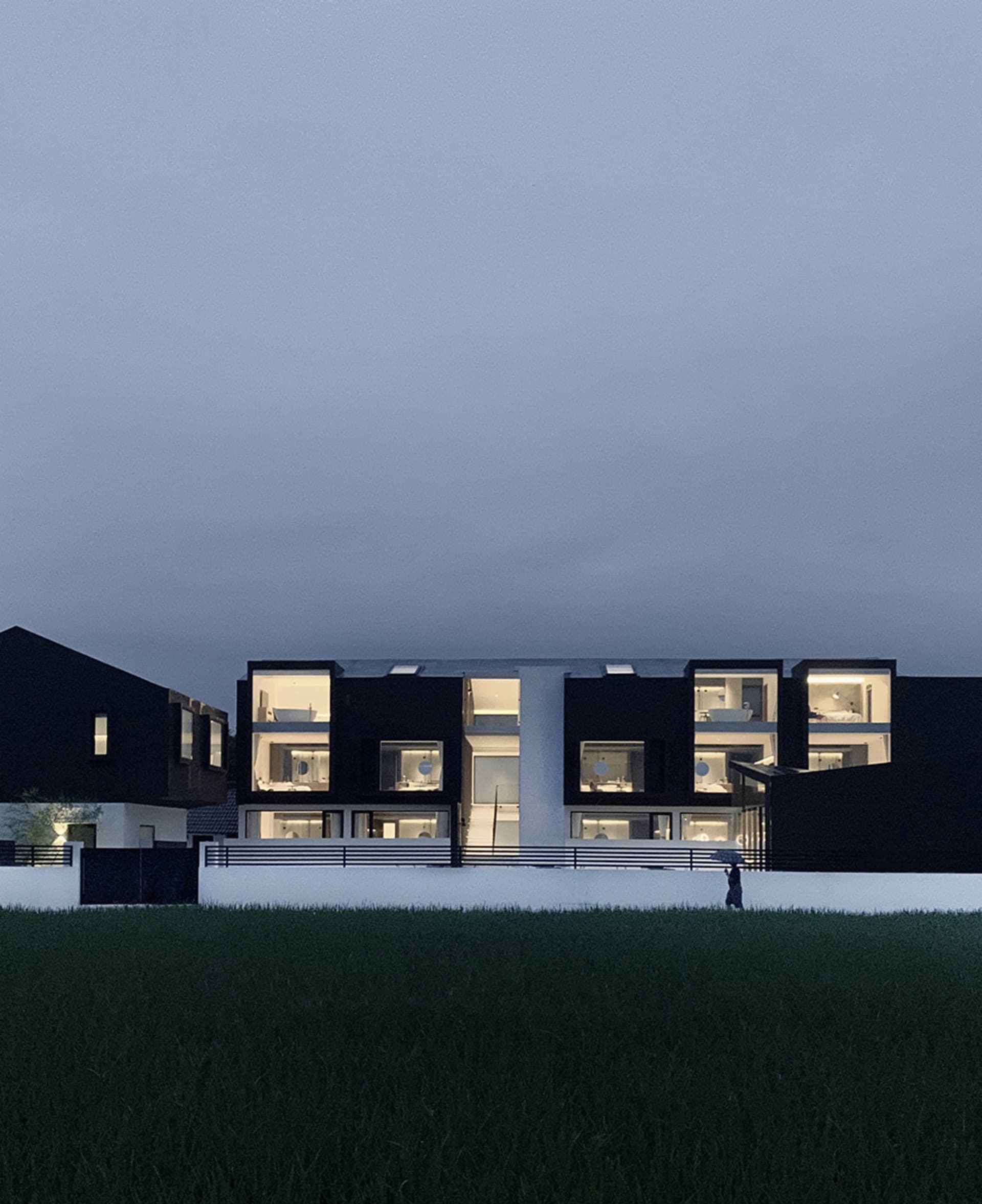 一座以混凝土與玻璃建造的現代住宅建築,擁有大面窗戶。