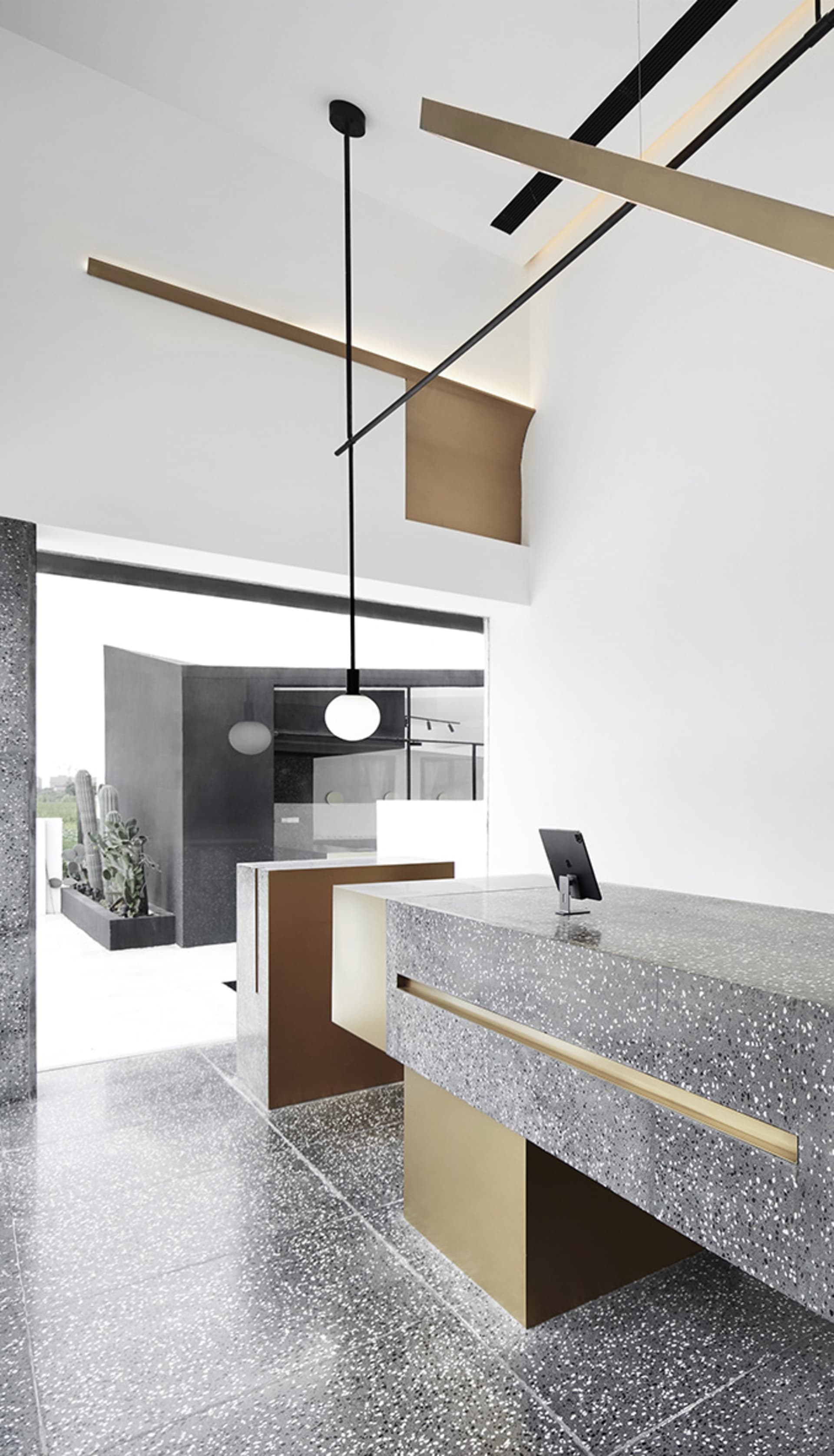 Modern retail cafe interior with a concrete and terrazzo counter featuring brass accents.