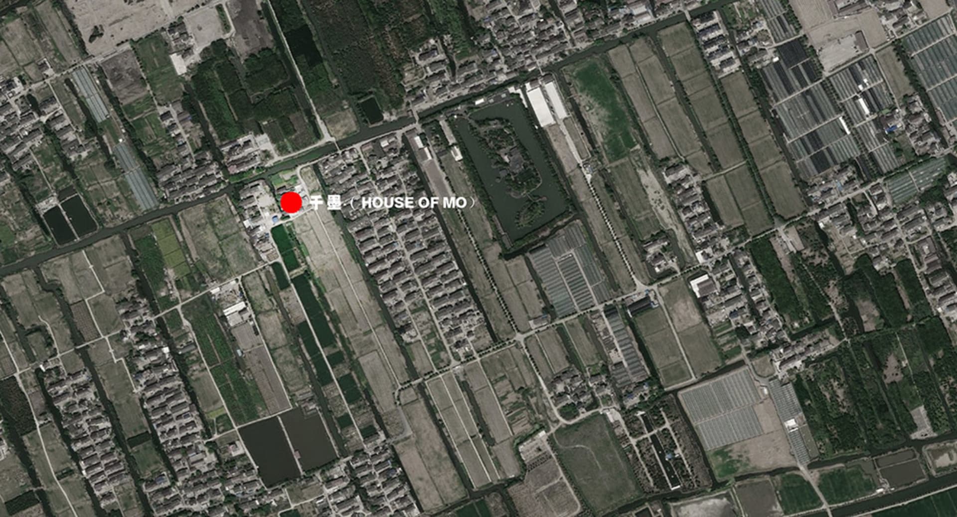 都市景觀的俯瞰視角，呈現草地、混凝土與瀝青表面。