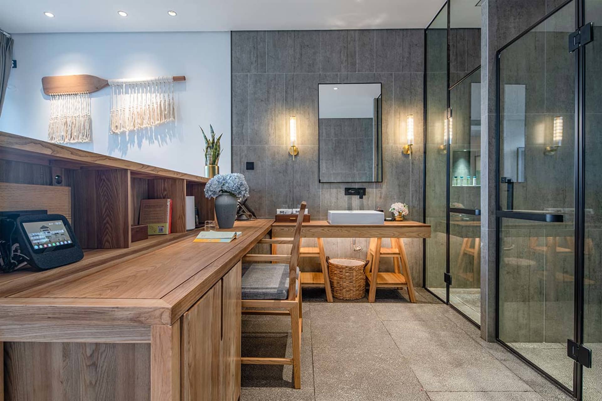 Modern bathroom featuring wooden accents, concrete walls, and glass elements