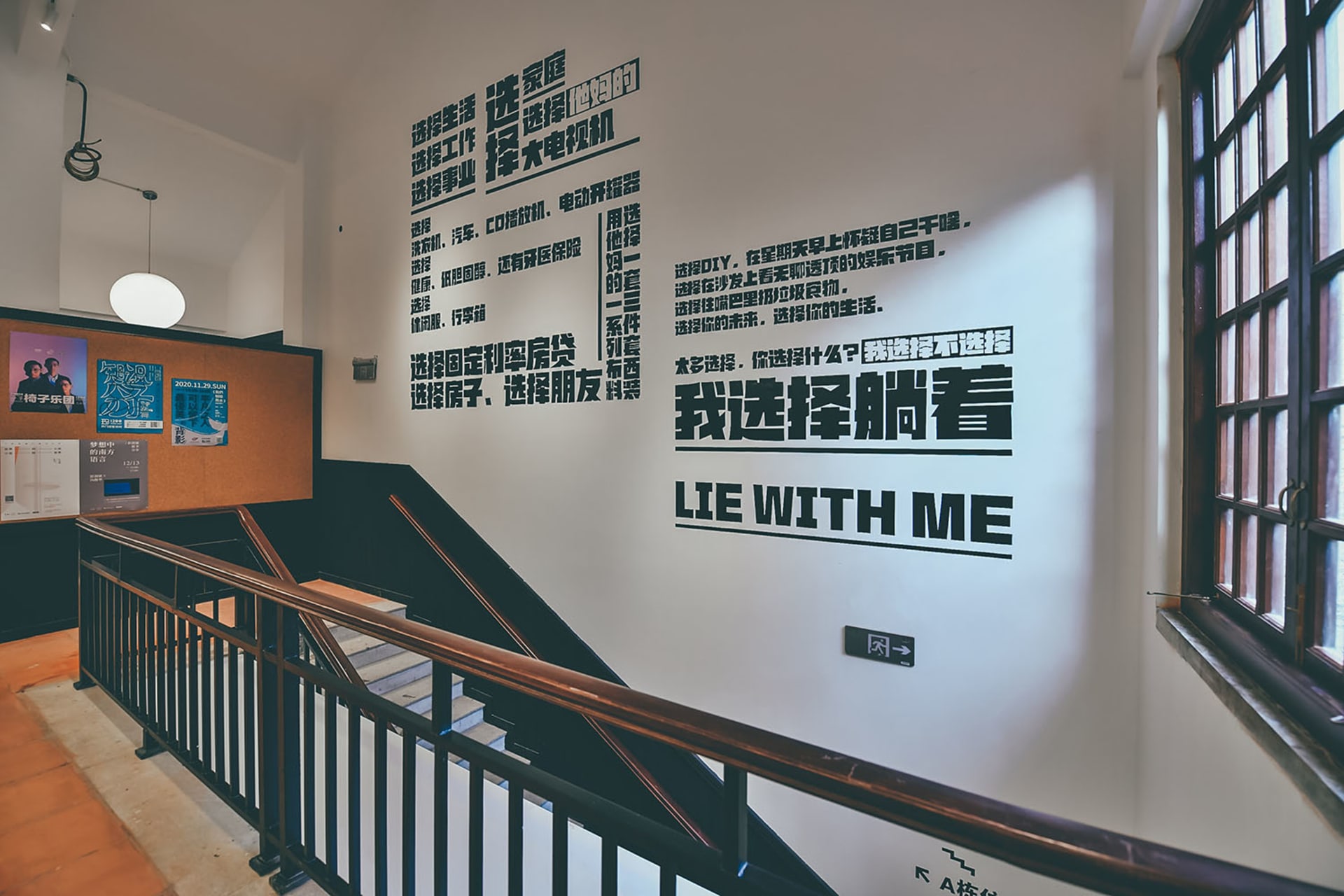 以文字為主的圖文設計印在白色牆面上,前景為樓梯,牆面展示多種中文字體