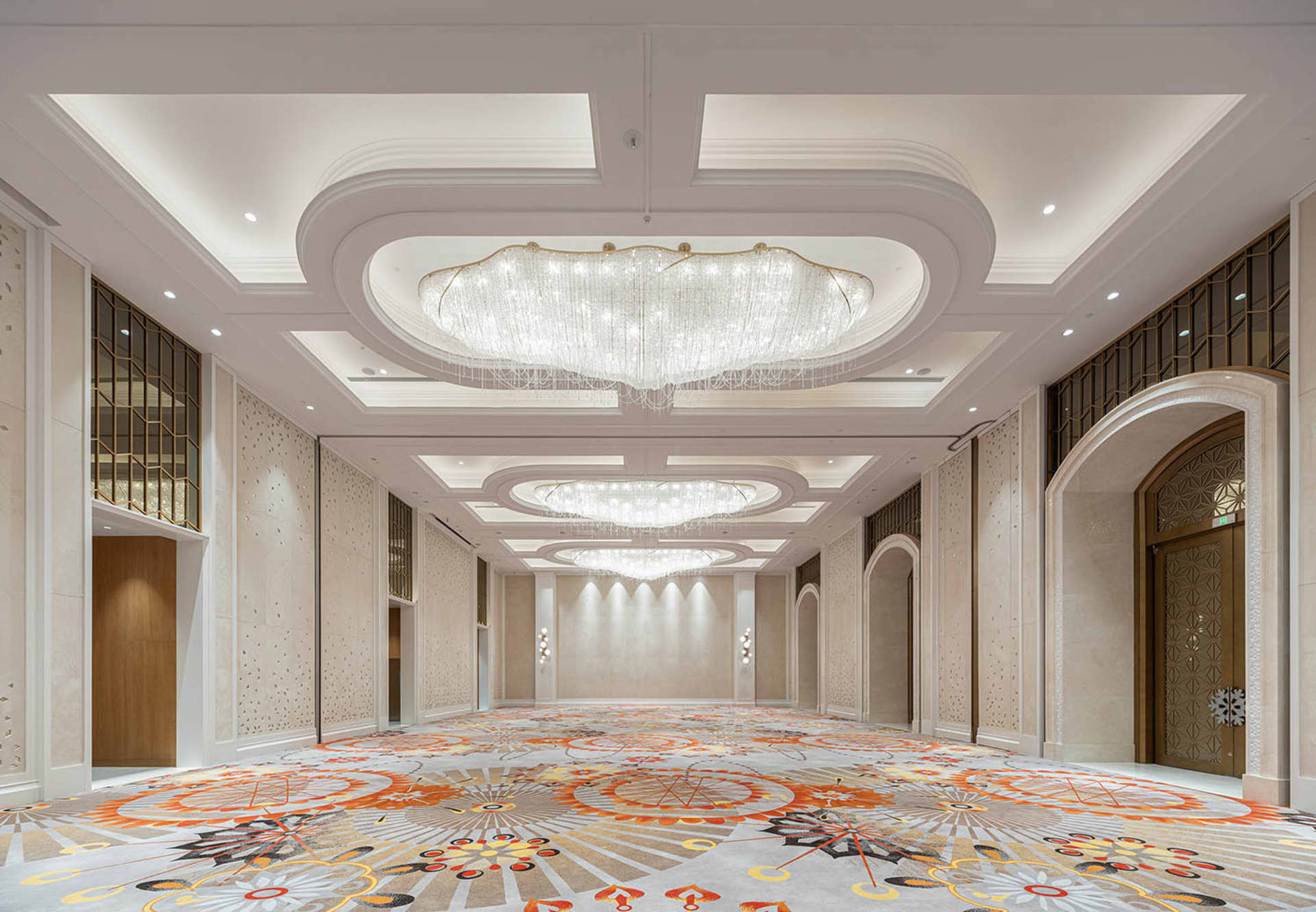 Spacious, modern banquet hall with marble accents and wooden paneling.