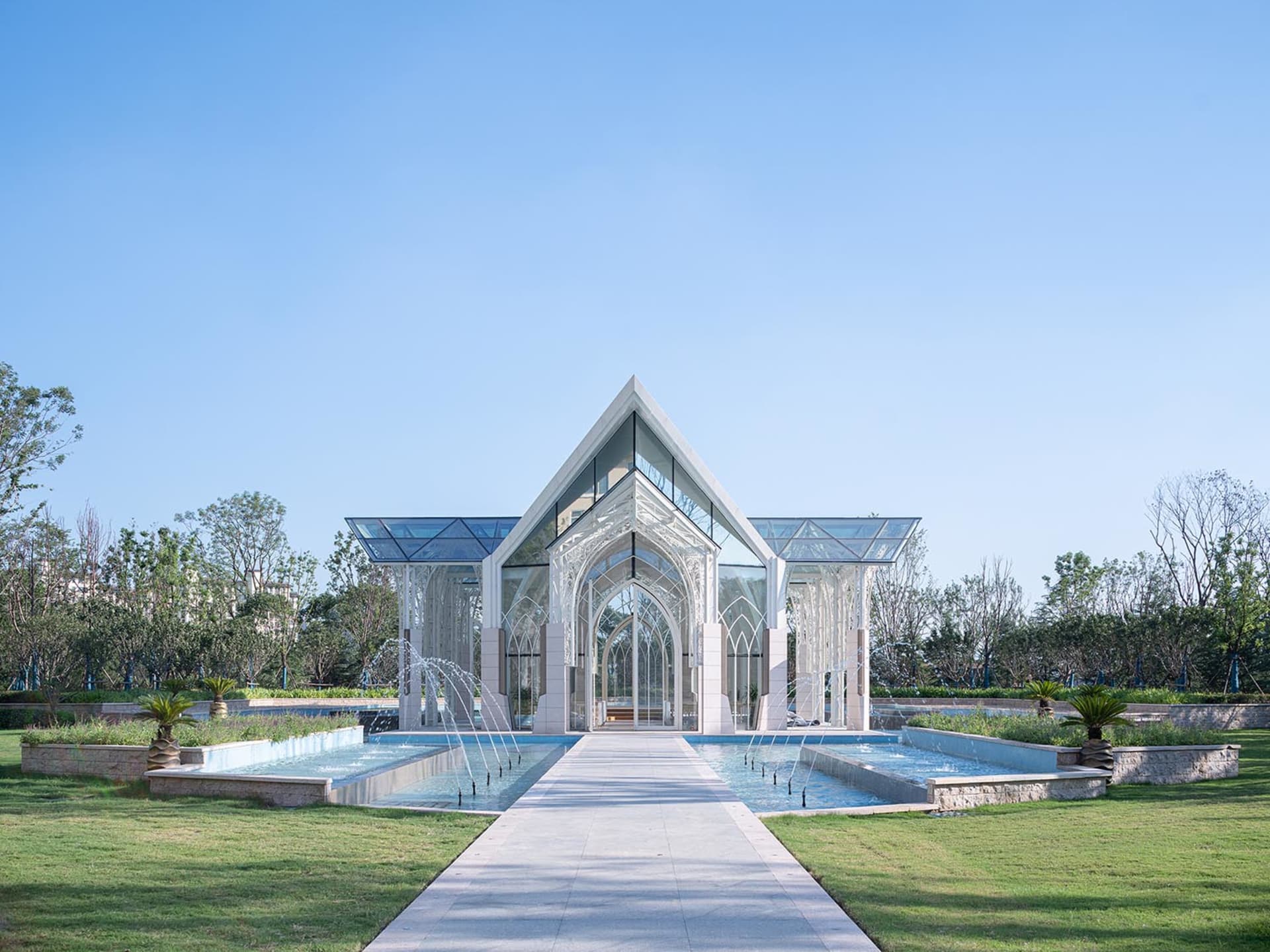 Modern glass church building with water fountain and pathways