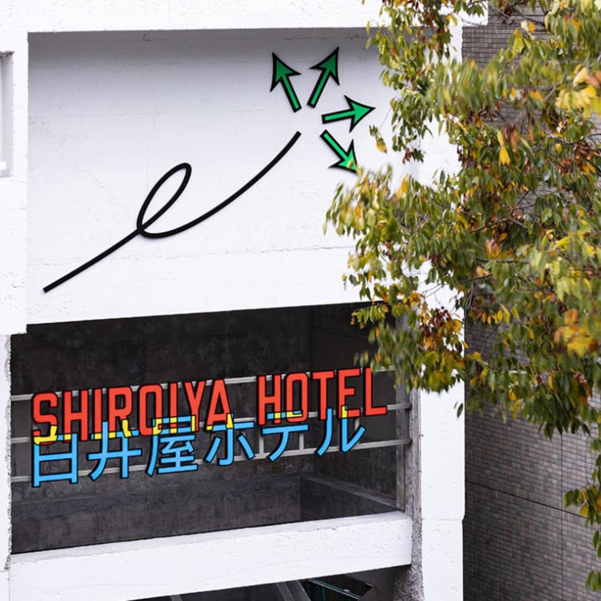 現代飯店入口，展示金屬框架招牌搭配霓虹燈光