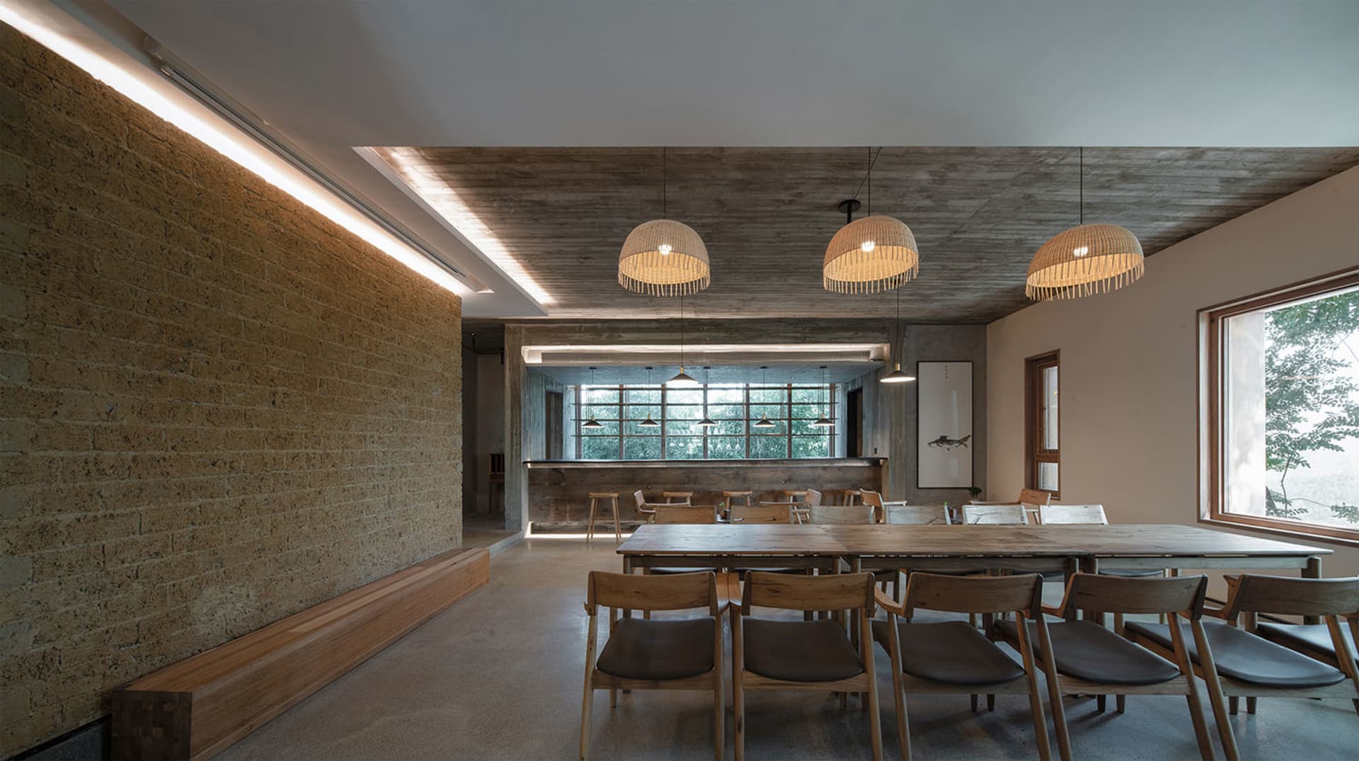 工業風餐廳室內,混凝土牆面、木質家具與吊燈。