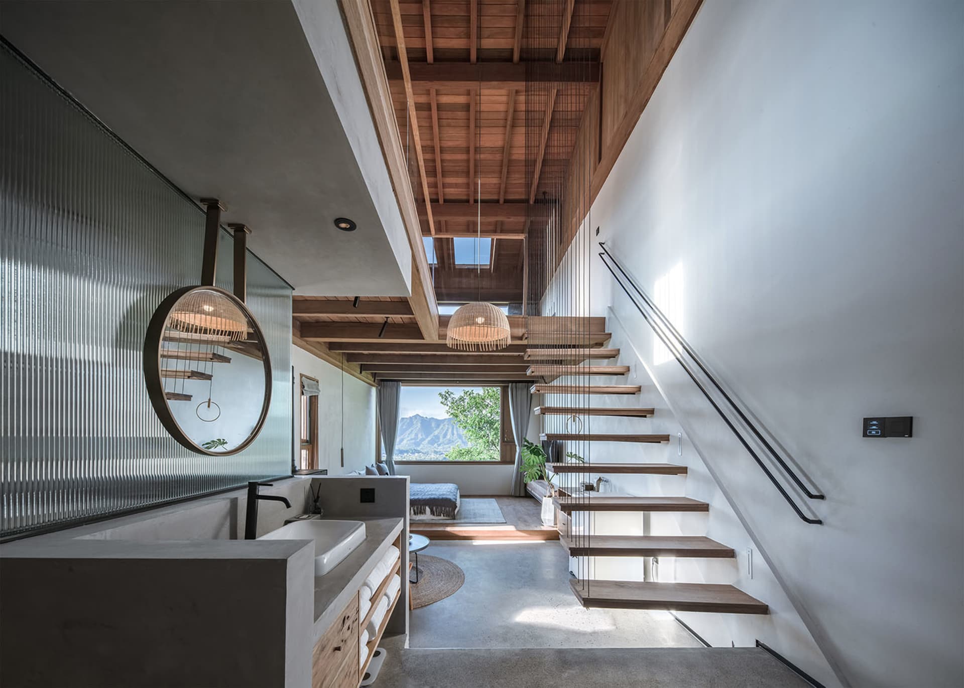 Modern bathroom with concrete floor and wood staircase viewed from above, showcasing minimalist design.