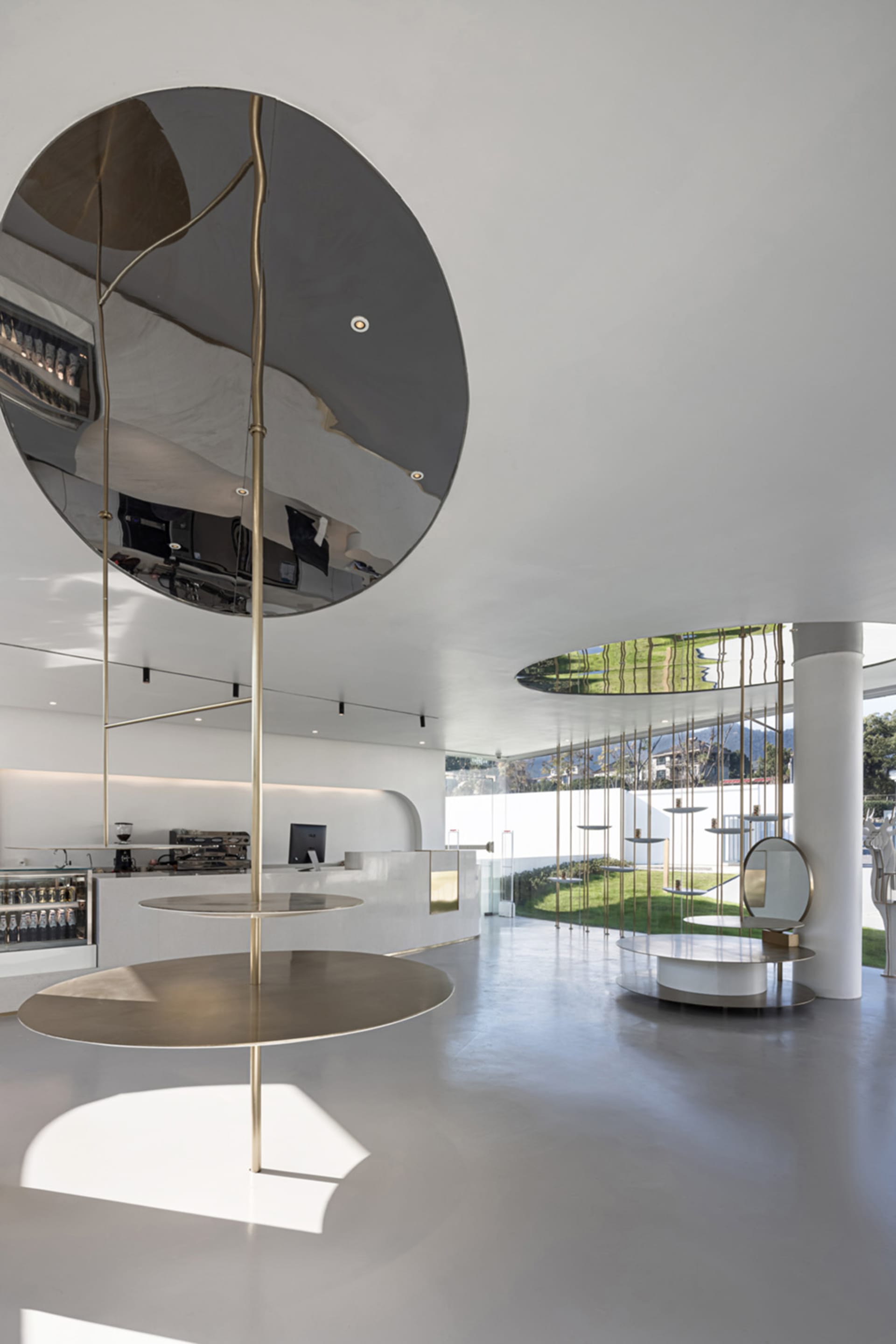 Modern coffee shop interior featuring minimalist design with metal and glass materials.