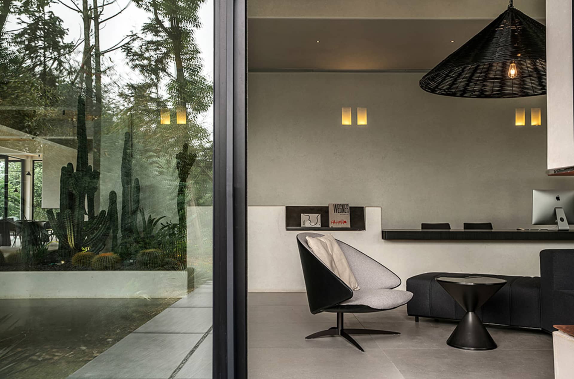Modern interior living space with concrete and glass materials, featuring a minimalist design.