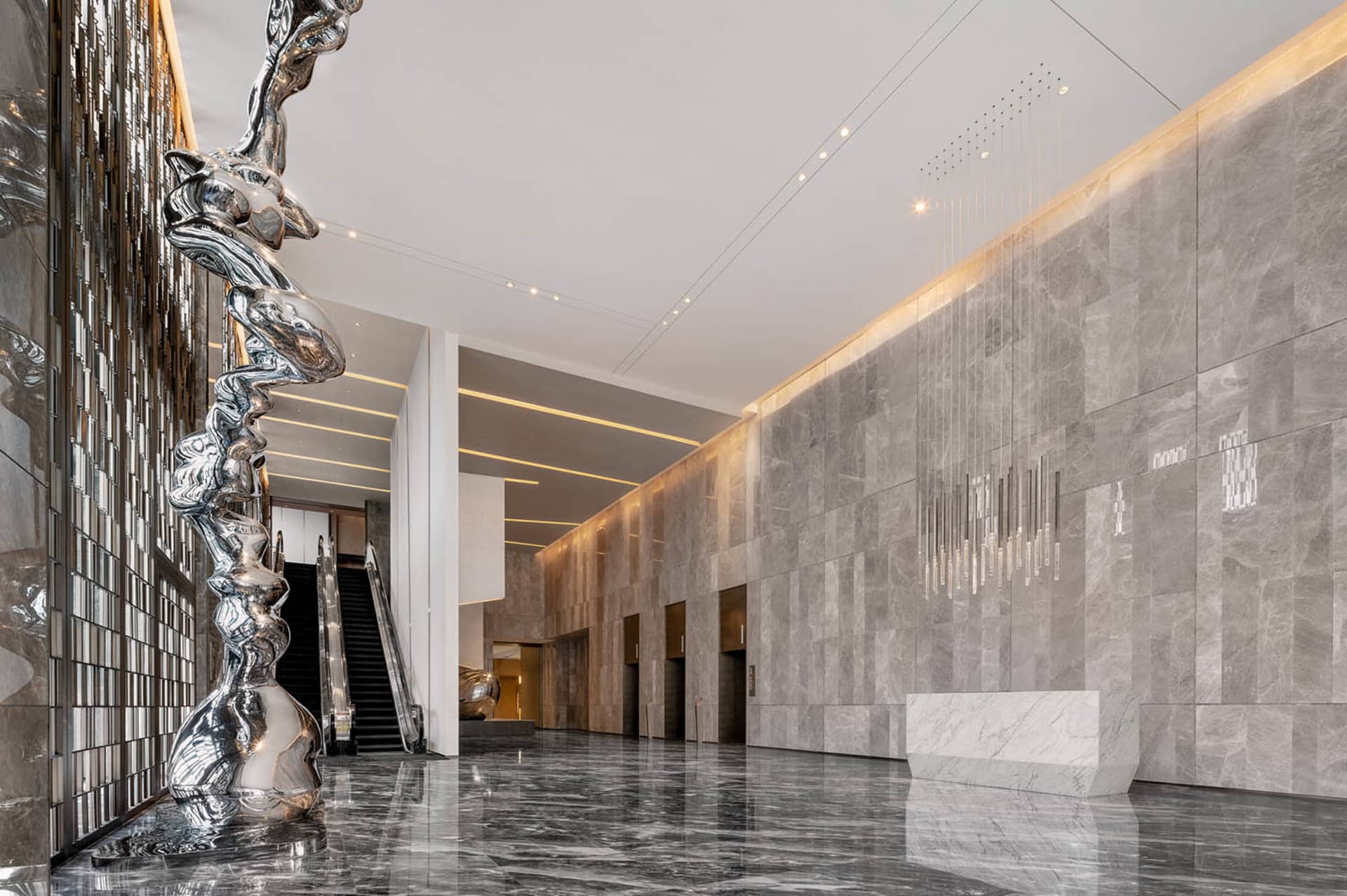 Modern lobby with marble finishes and sculptures.