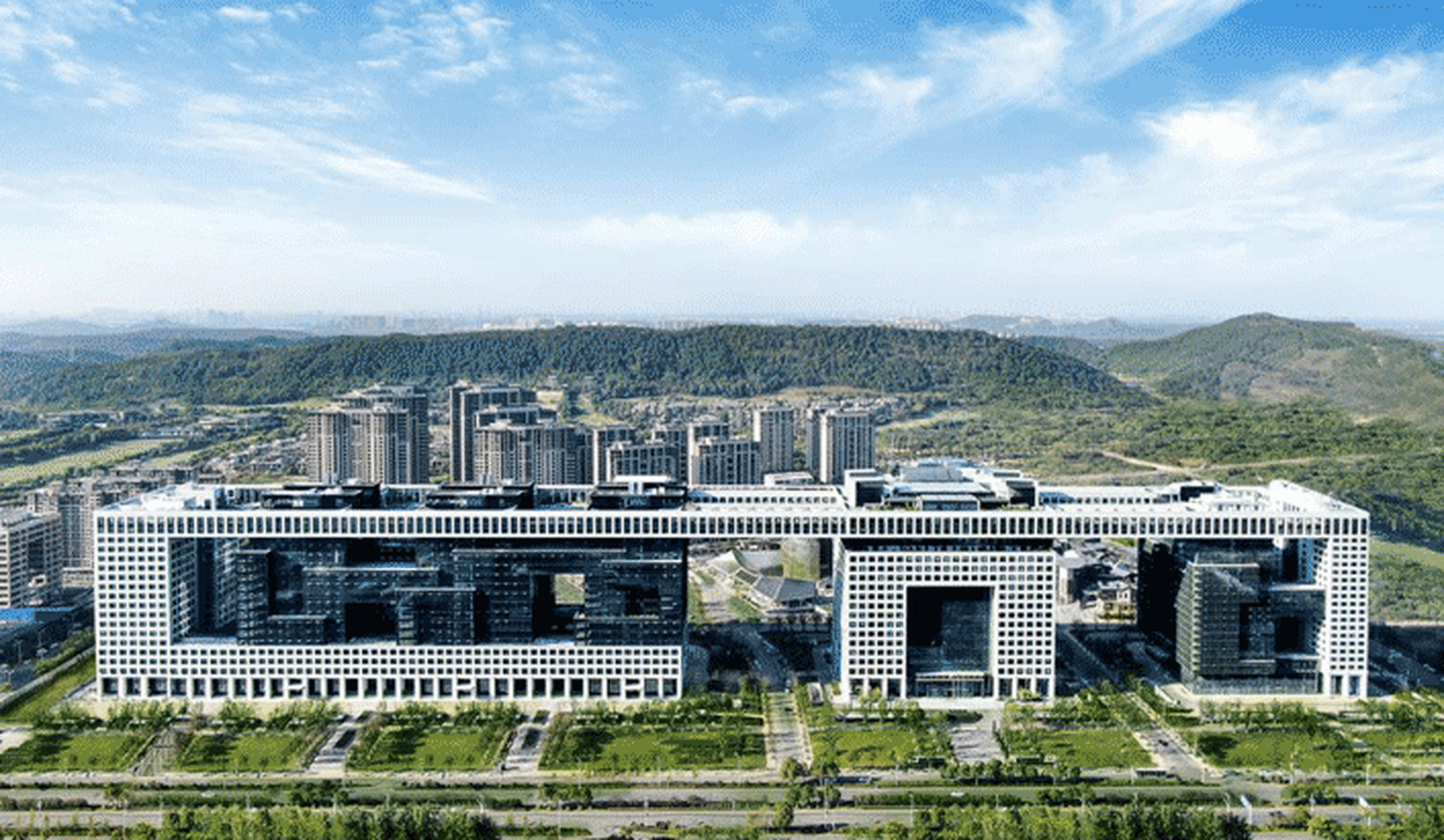 Modern office campus with large glass structures and greenery.