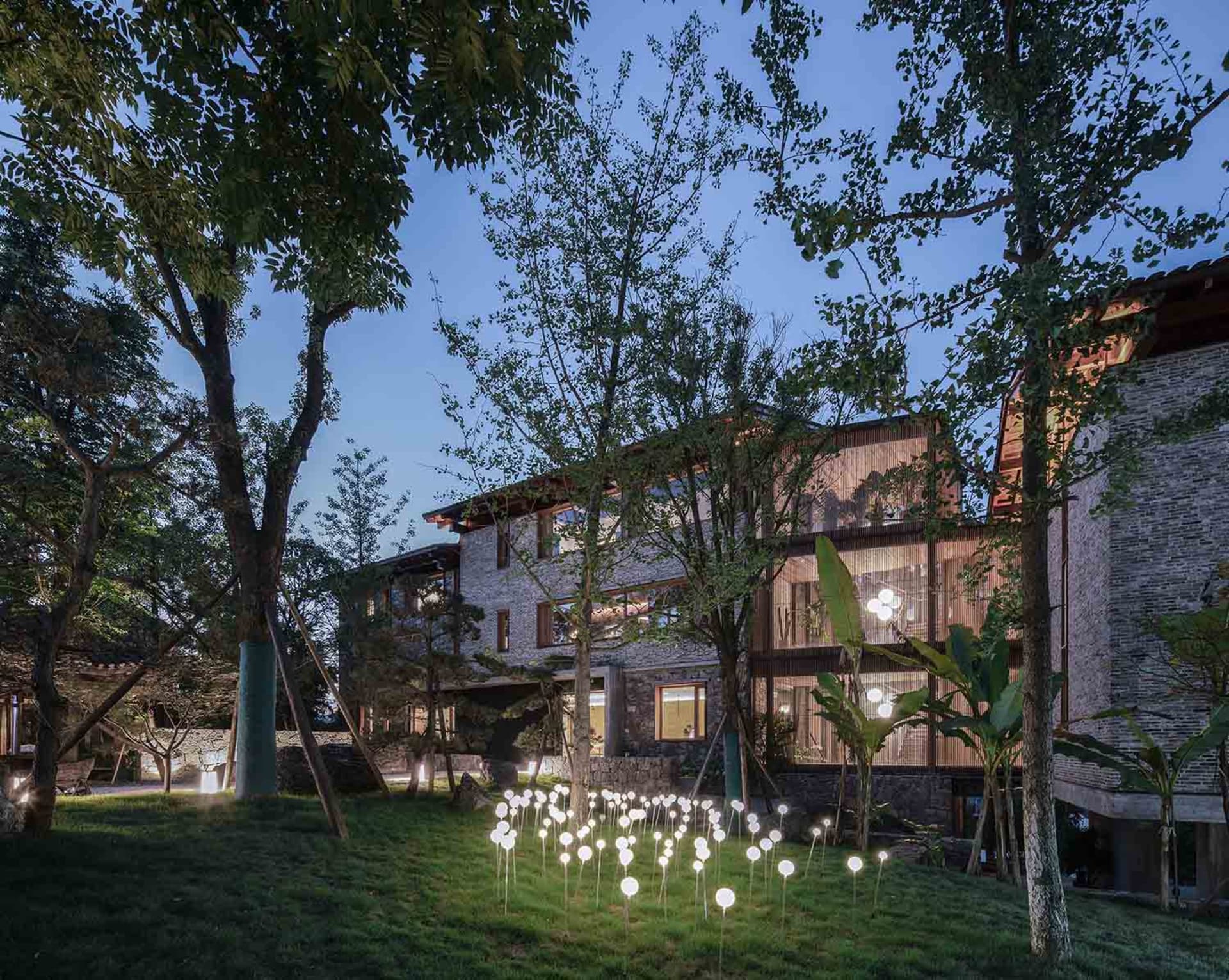 一座現代住宅外觀,採用石材、磚塊與鋁材打造。