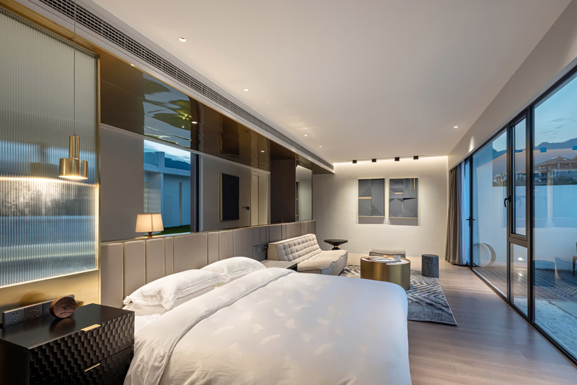 A modern luxurious bedroom suite with marble flooring and large windows.
