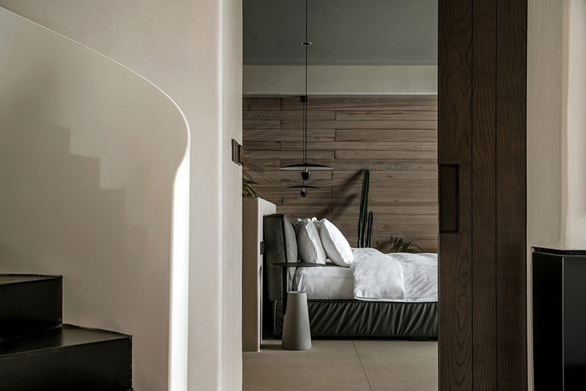 A modern bedroom with brown wooden walls and a minimalist bed setup.