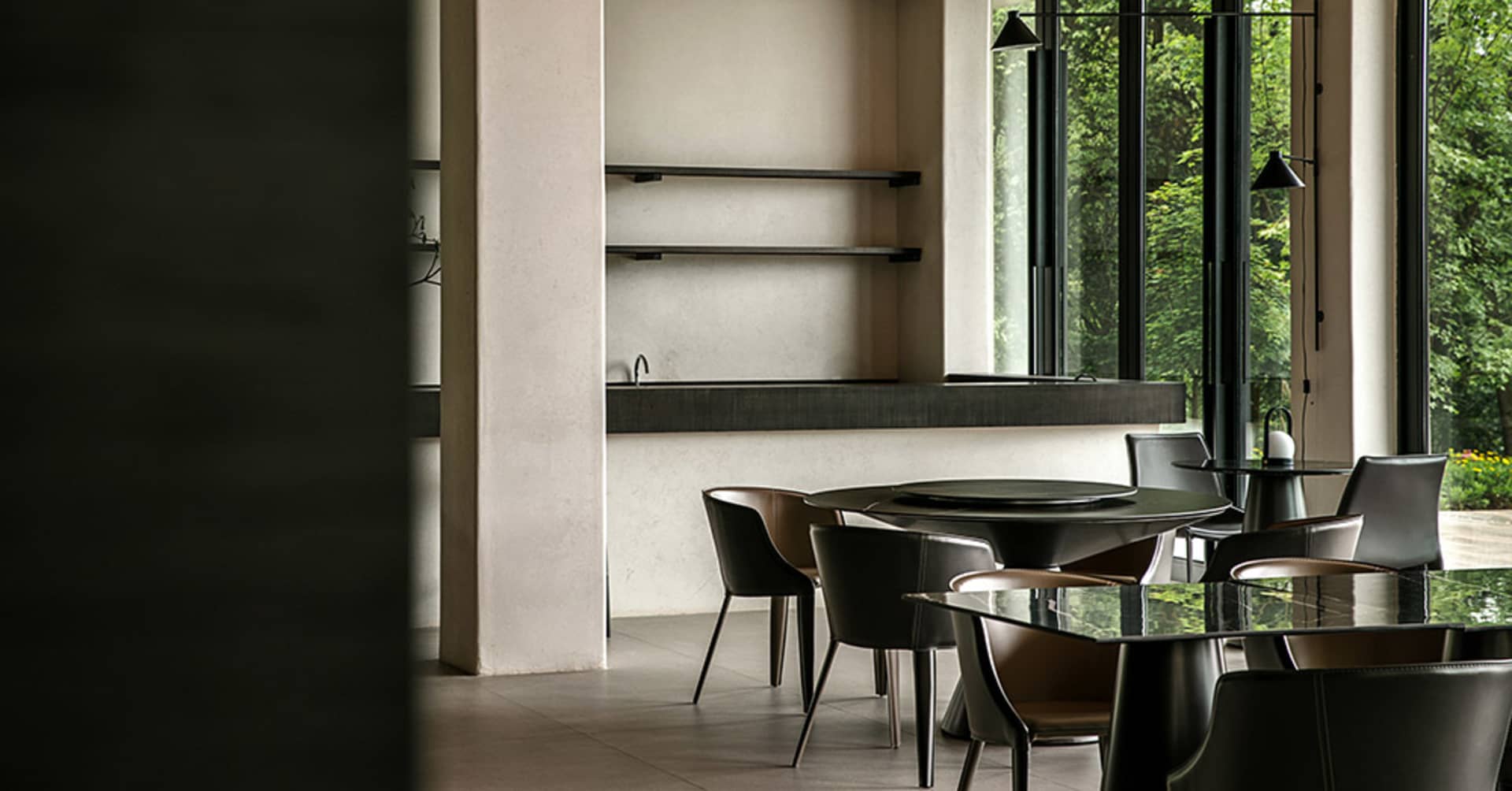 A modern dining room with glass tables and matte-finished chairs, featuring a minimalist design and a sleek, contemporary aes