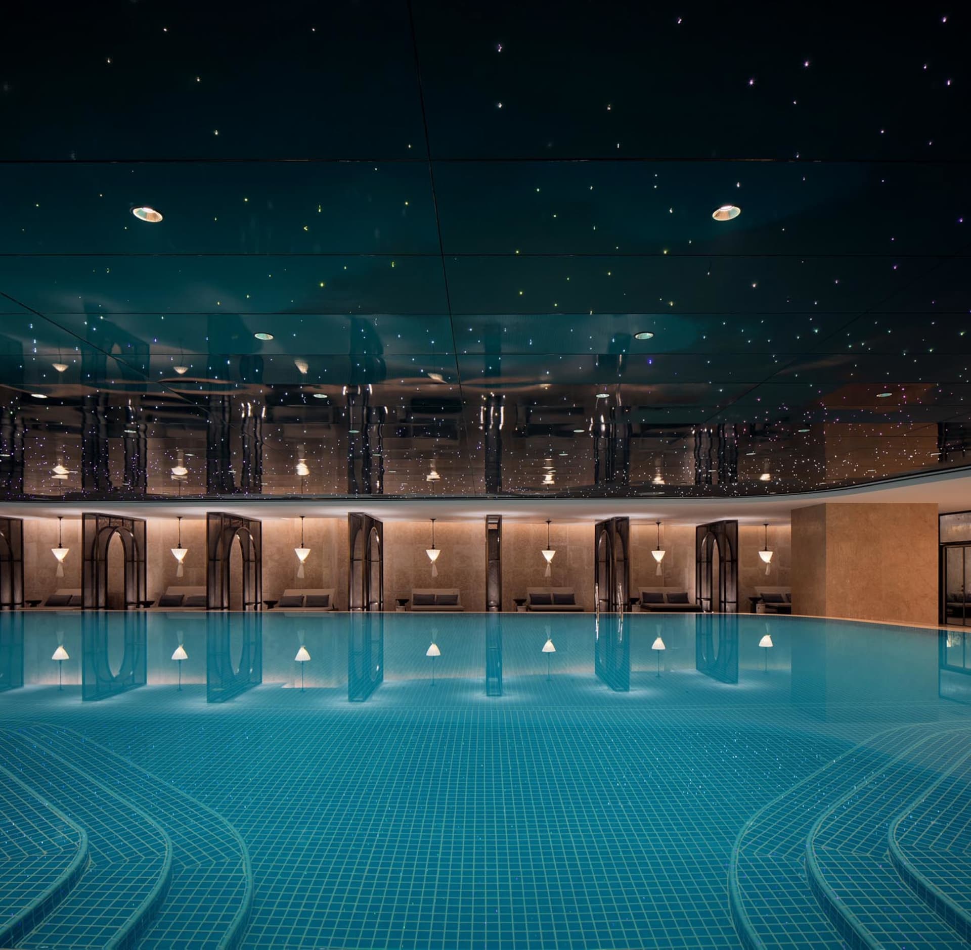 Swimming pool interior with glass tiles and concrete ceiling