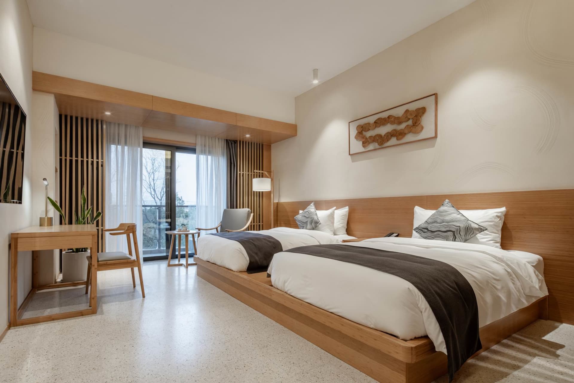 A modern residential bedroom with a wooden floor and furniture.