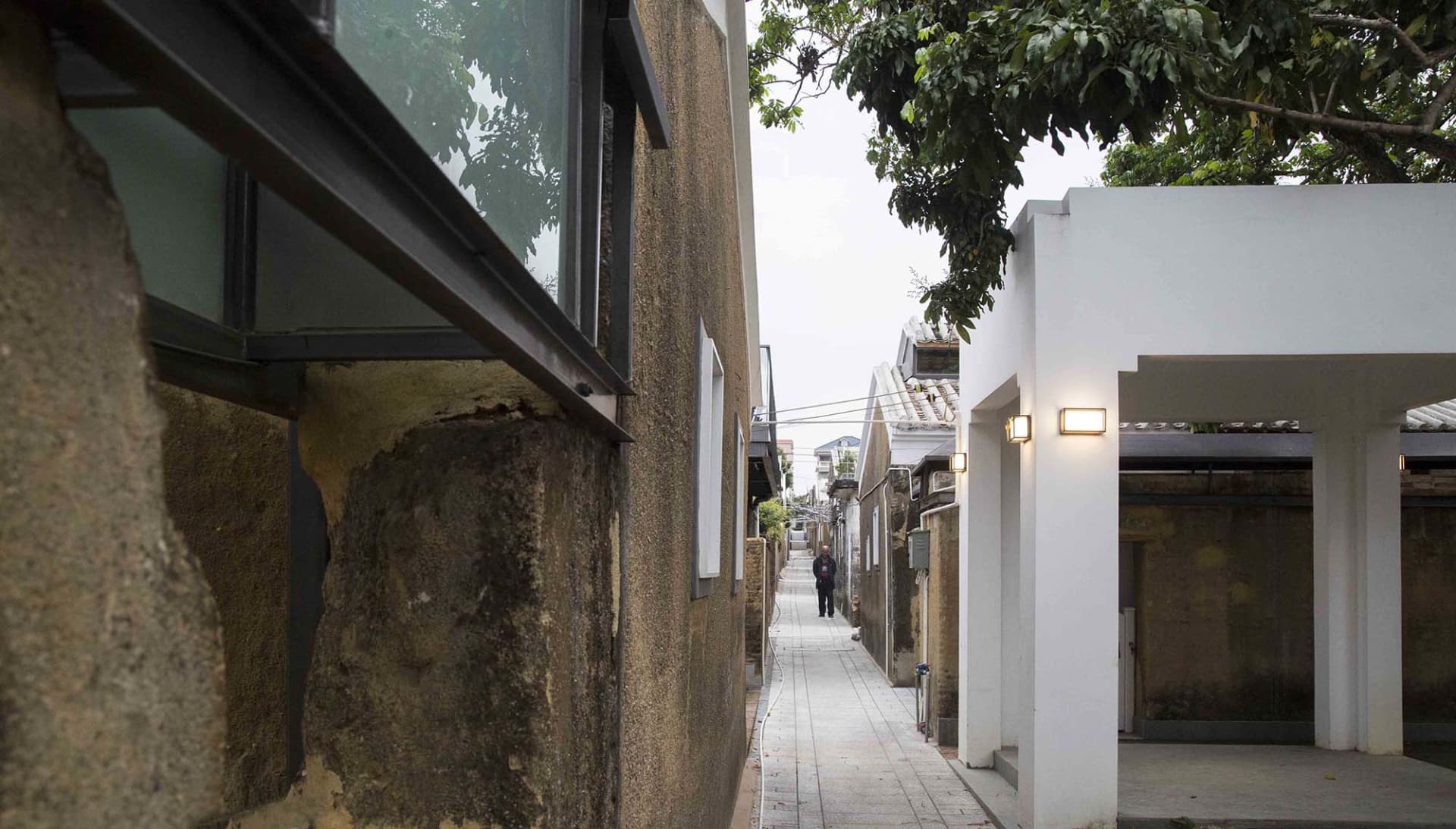 混凝土街景，伴隨綠意與行人步行。