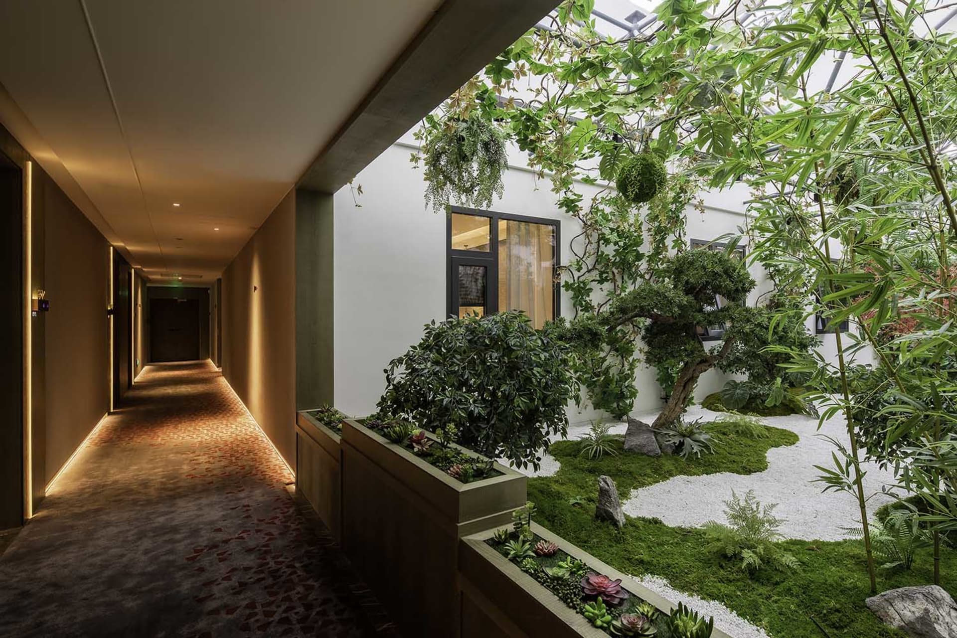 An interior space featuring a green roof garden with concrete structures and lush green vegetation.