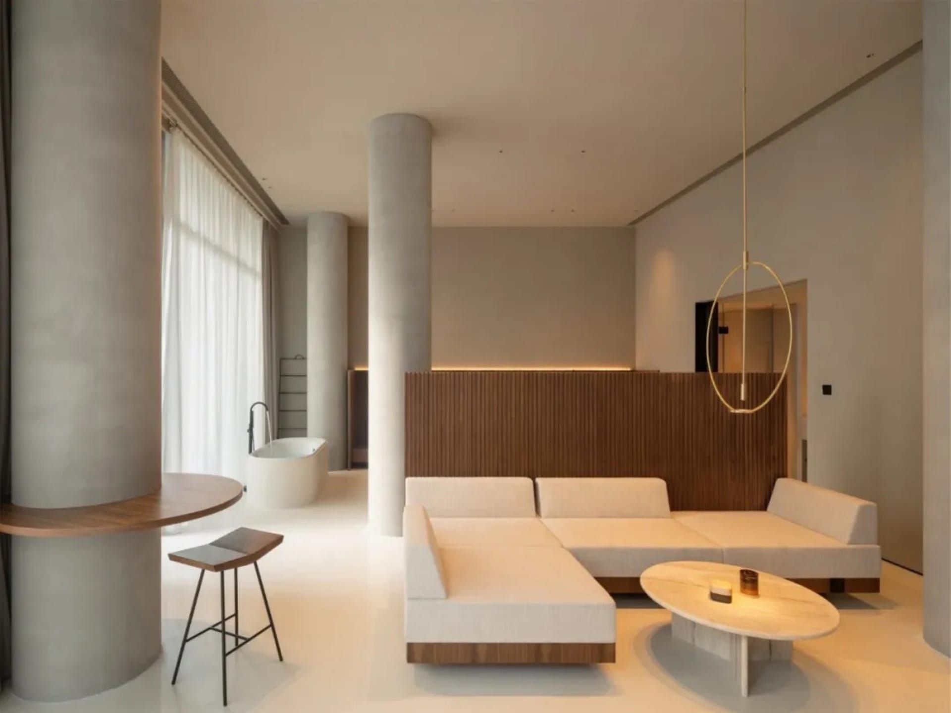 A minimalist apartment with a concrete floor, wooden furniture, and a circular light fixture.