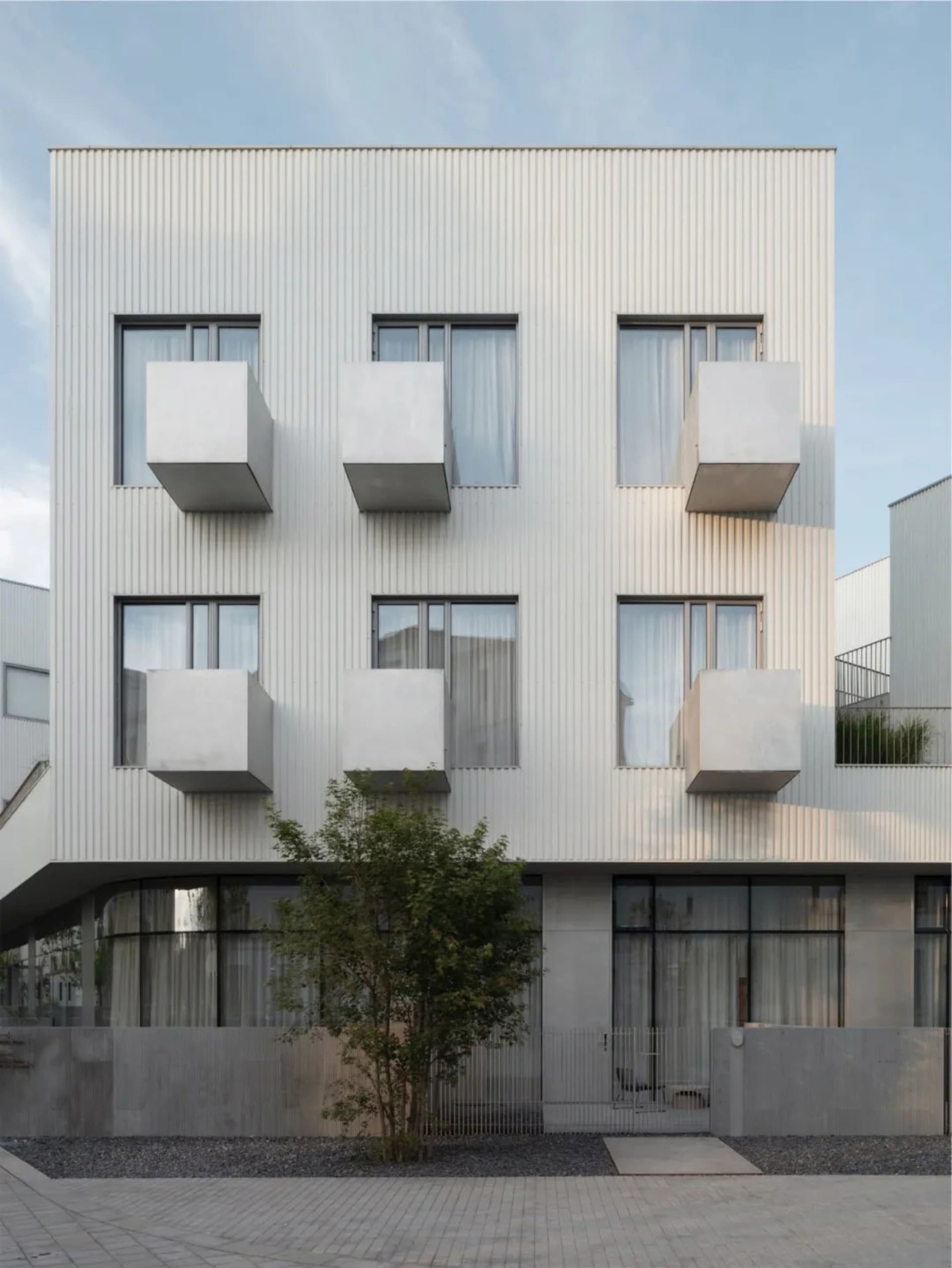現代建築外觀，混凝土牆面搭配大型窗戶。