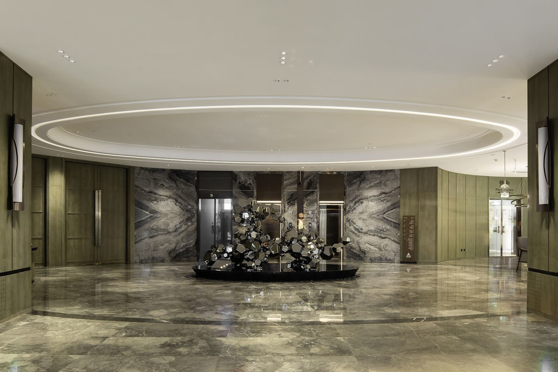 A modern lobby interior with marble flooring, glass walls, and concrete columns.