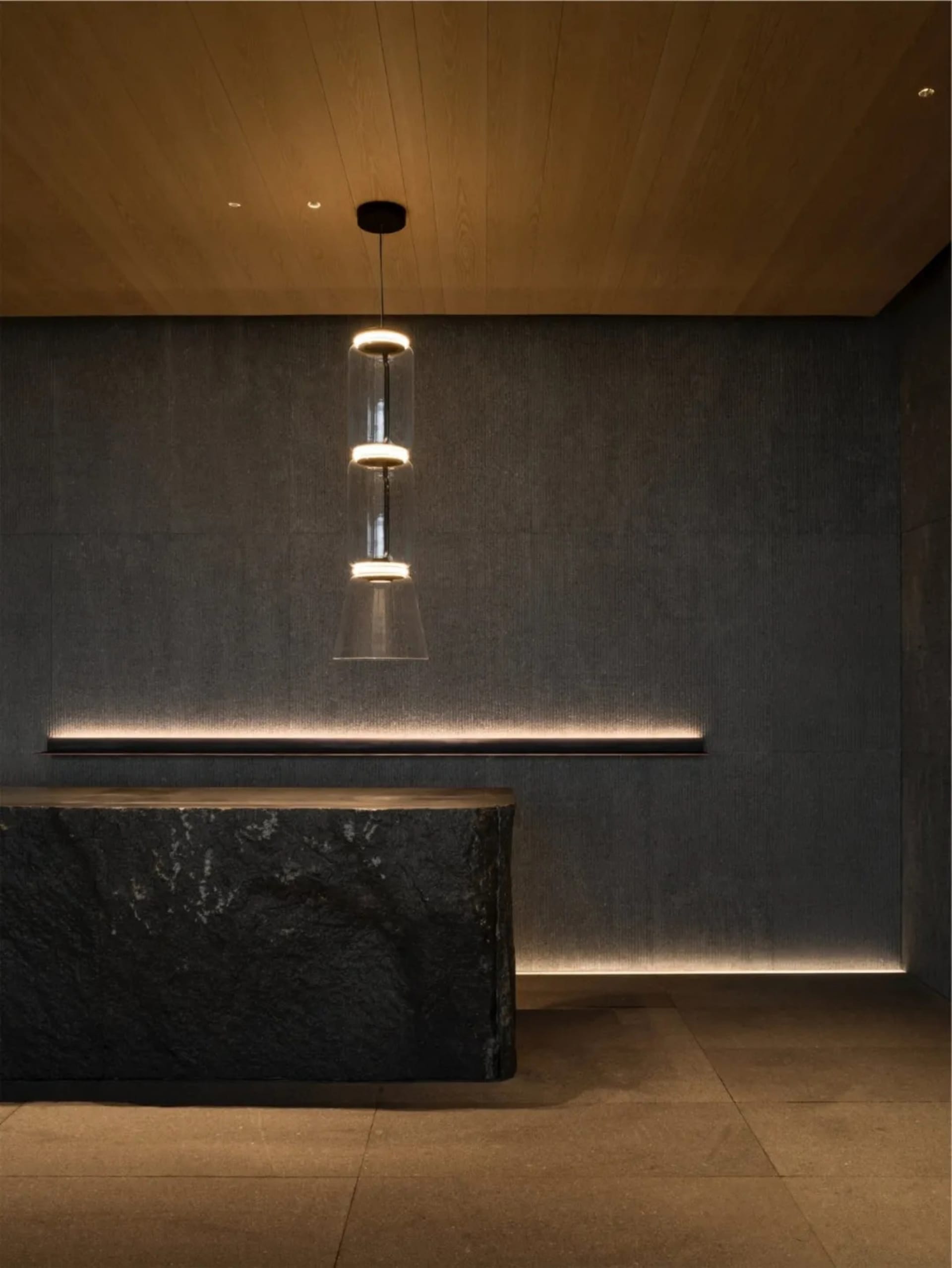 A modern reception desk with a concrete surface and ambient lighting in an interior setting.