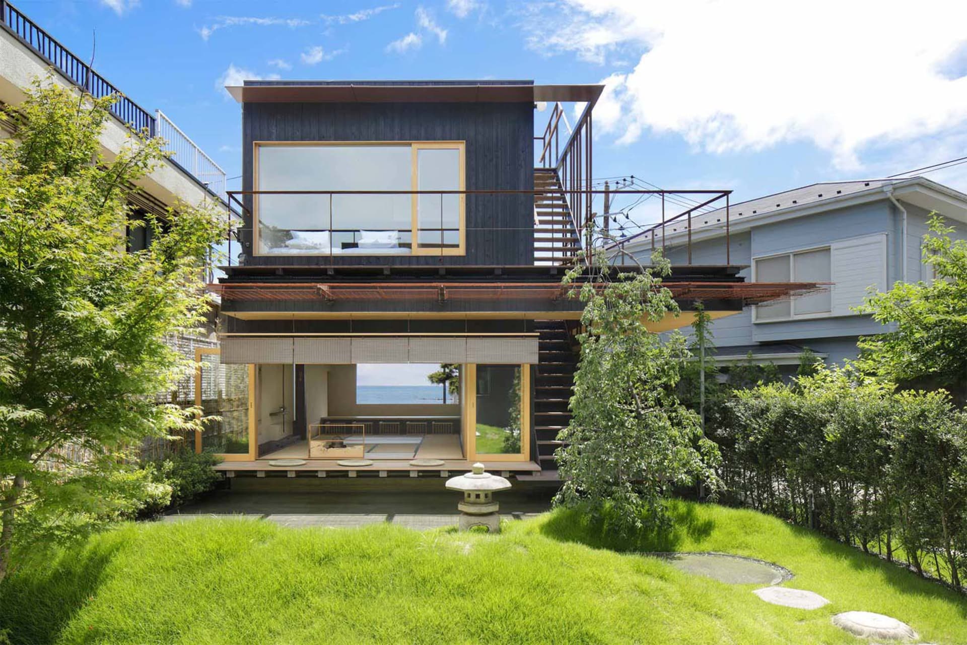 A modern house with wooden exterior and large glass windows.